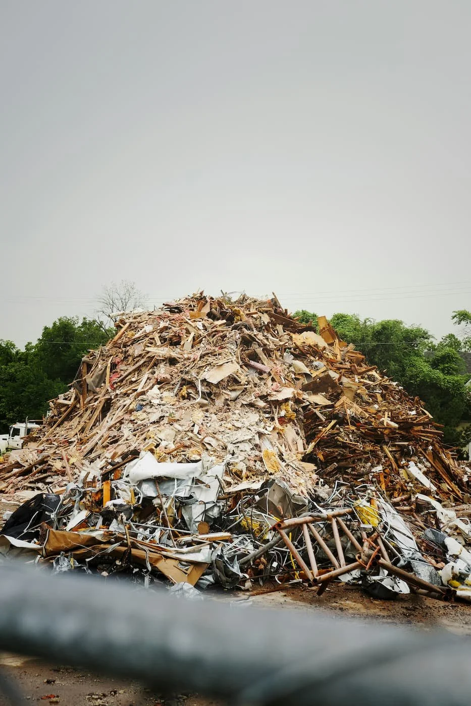 A large pile of construction debris and broken materials with mixed waste that may contain hazardous construction waste.