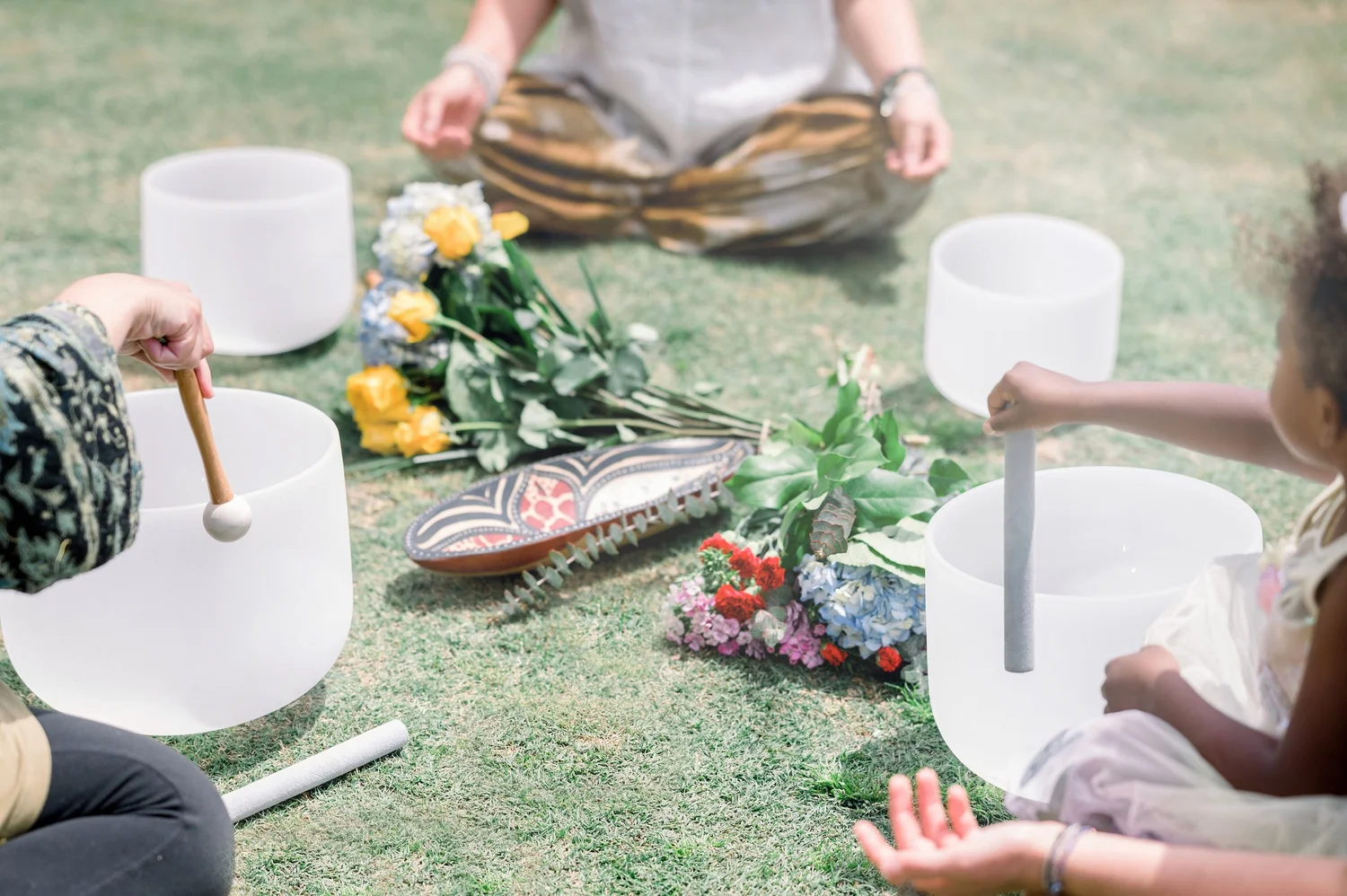 Crystal singing bowls and flowers on the grass