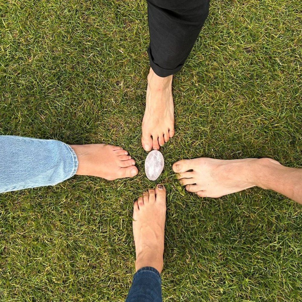 Bare feet meeting in a circle on the grass
