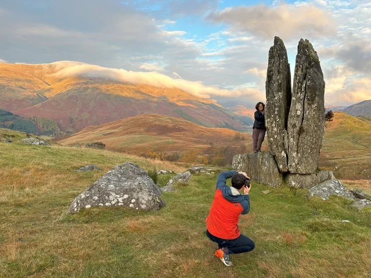 A traveller kneeling in prayer before the standing stones