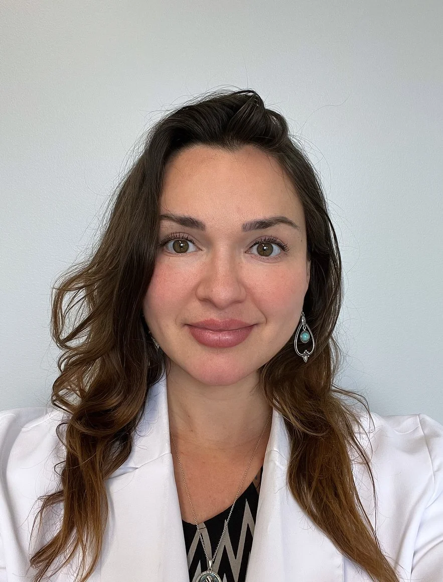 Owner Danelle in a white coat smiling at the camera