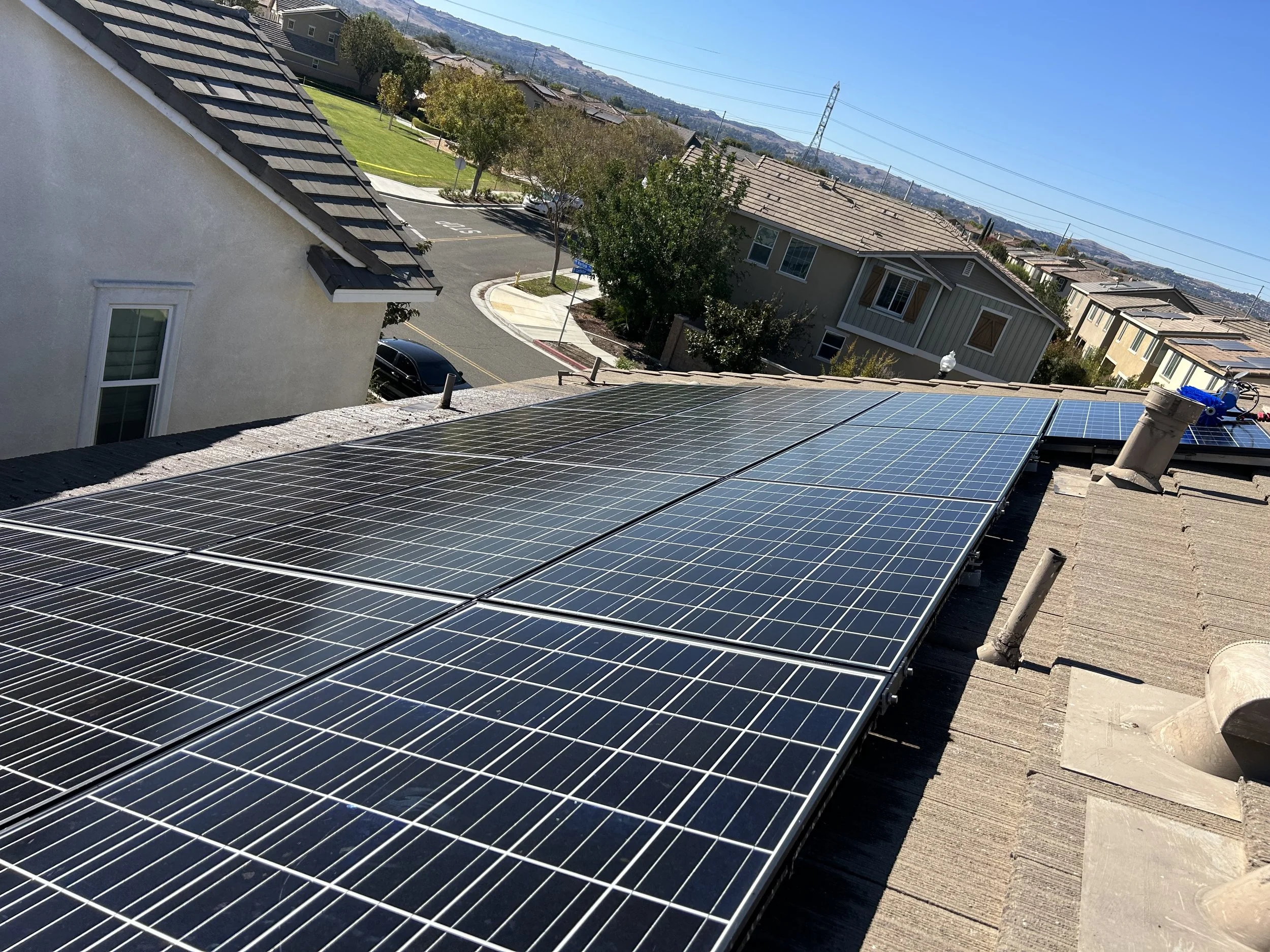 Solar panels installed on a residential rooftop in a suburban neighborhood.