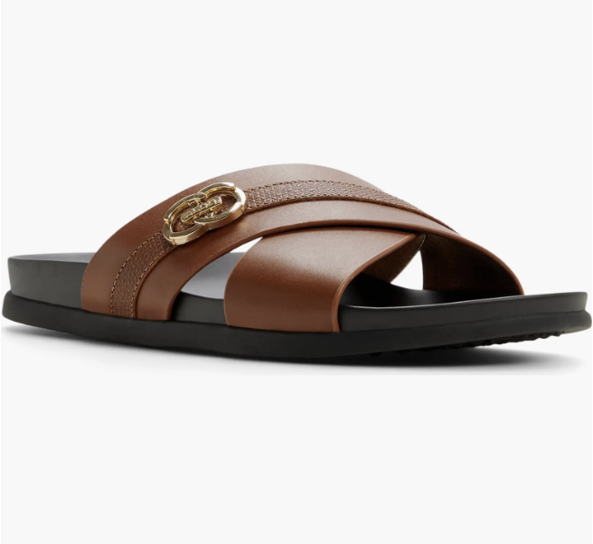 A pair of men's brown leather dress sandals featuring wide criss-cross straps and a gold buckle detail, styled for a refined 2026 summer resort look.