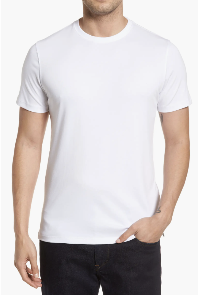 Close-up of a man wearing a crisp white crew neck t-shirt with a structured collar, tucked into dark navy trousers for a classic men's minimalist look.