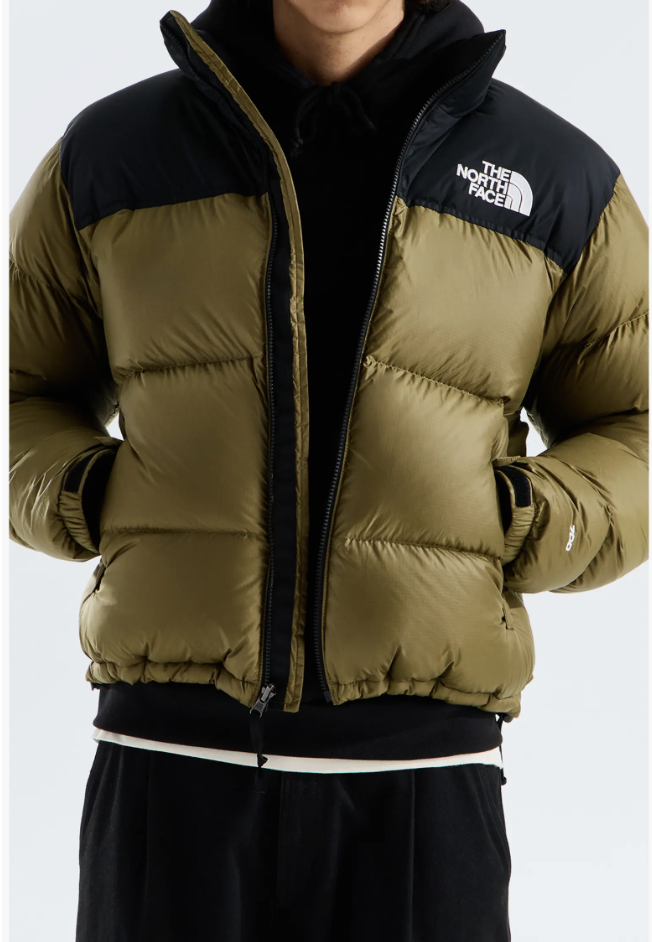Man wearing The North Face 1996 Retro Nuptse Down Jacket in olive with black shoulders over a black hoodie.