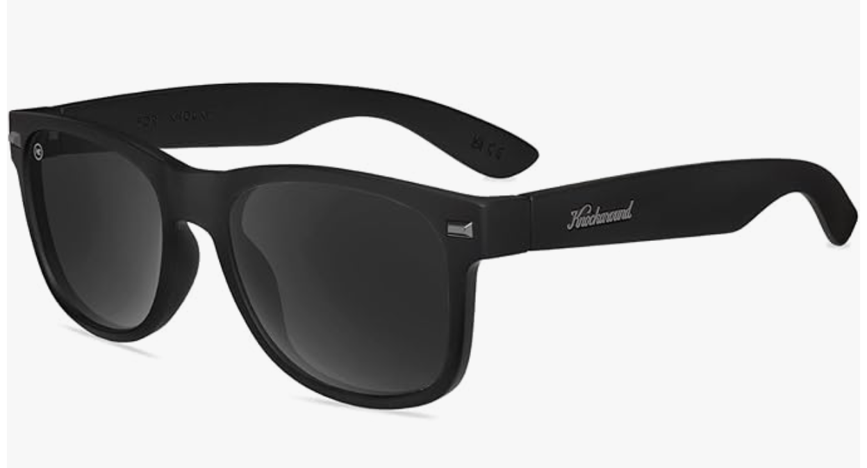 A studio shot of Knockaround Fort Knocks sunglasses featuring a matte black classic square frame, dark smoke lenses, and a silver logo accent on the temple.