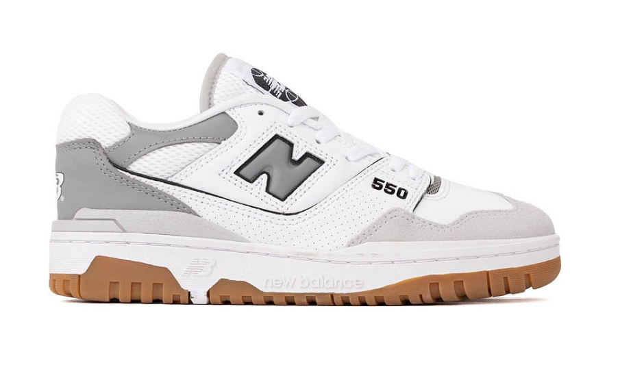 A side profile view of a New Balance 550 sneaker in a clean white and grey colorway, showcasing its retro basketball silhouette and classic gum rubber outsole.