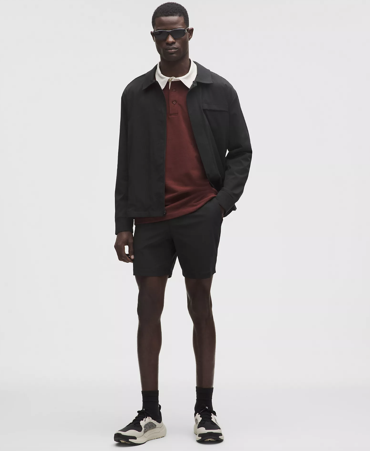 A man wearing black Lululemon ABC Classic-Fit 7-inch shorts, styled with black crew socks and cream athletic sneakers for a premium sporty look.