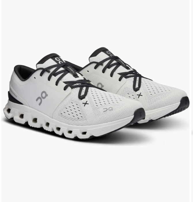 A side profile view of a white leather Veja V-10 sneaker featuring the brand's signature black 'V' logo, a perforated toe box, and an off-white rubber sole.