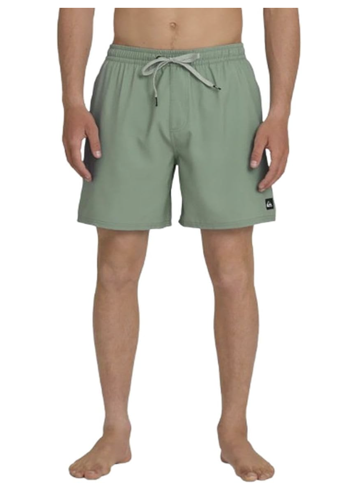 Mid-thigh view of a model wearing mint green Quiksilver Everyday Volley swim trunks, showcasing the comfortable elastic waistband, grey adjustable drawstring, and subtle logo patch on the lower left hem.