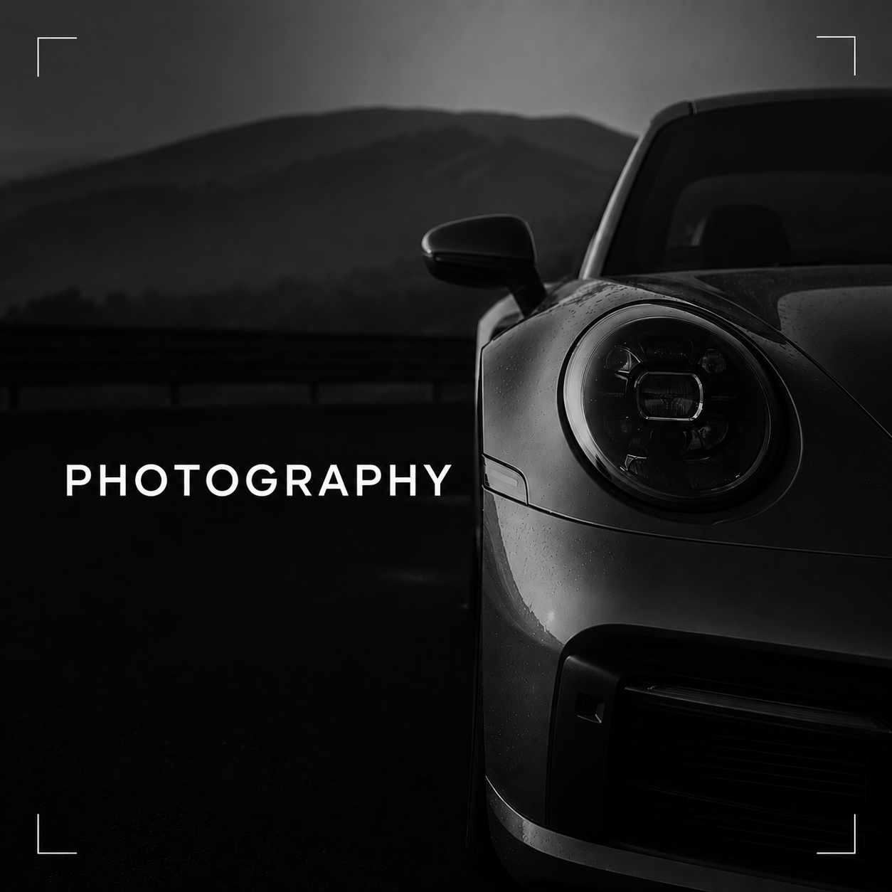 Close-up of a sleek sports car with raindrops on its surface, set against a dark, mountainous background, with the word 'PHOTOGRAPHY' overlaid.