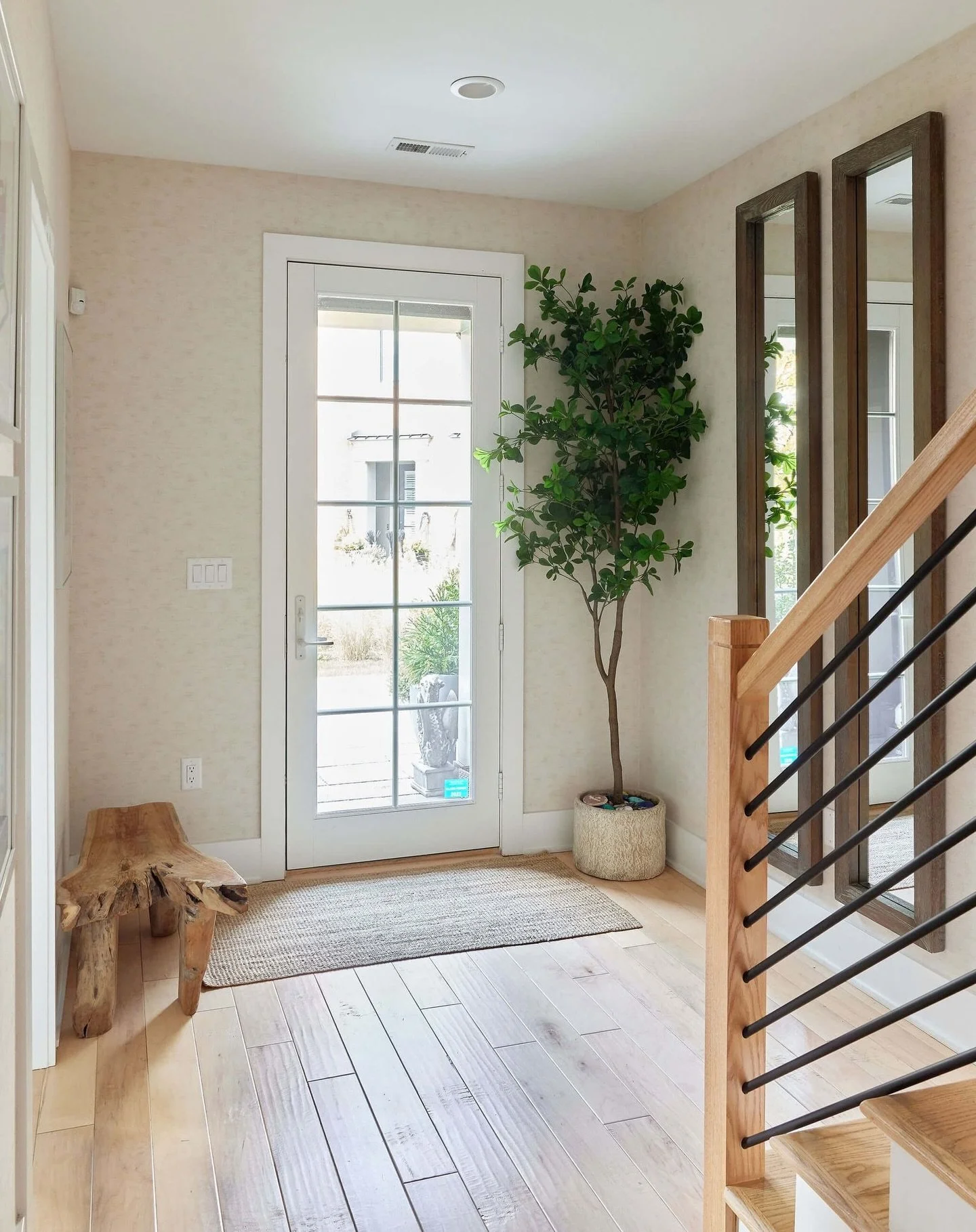 In this Sleepy Hollow family townhouse, subtle layers of texture and natural materials make the space feel warm, welcoming, and lived in from the moment you walk through the door. The @phillipjeffriesltd vinyl wallpaper with a subtle print, wood tone
