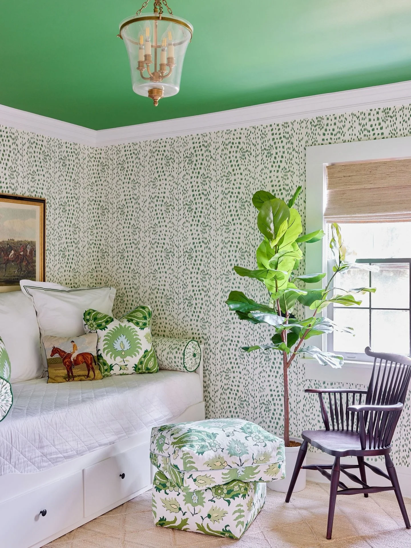 In this Tarrytown family home, we layered @brunschwigfils wallpaper with two of their fabrics to create a space that feels cohesive, comfortable, and full of personality. From the upholstered ottoman to the patterned walls and green ceiling, each ele