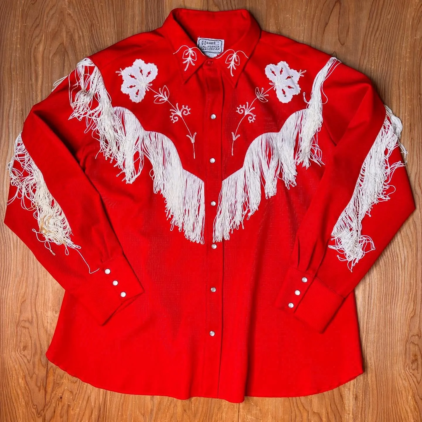 Cherry bomb magic, stitched and swinging.This vintage H Bar C pearl snap is a full-on showstopper! Bright cherry red with silky white fringe that moves like a honky tonk slow dance. From a legendary western label, it&rsquo;s decked out with crisp whi