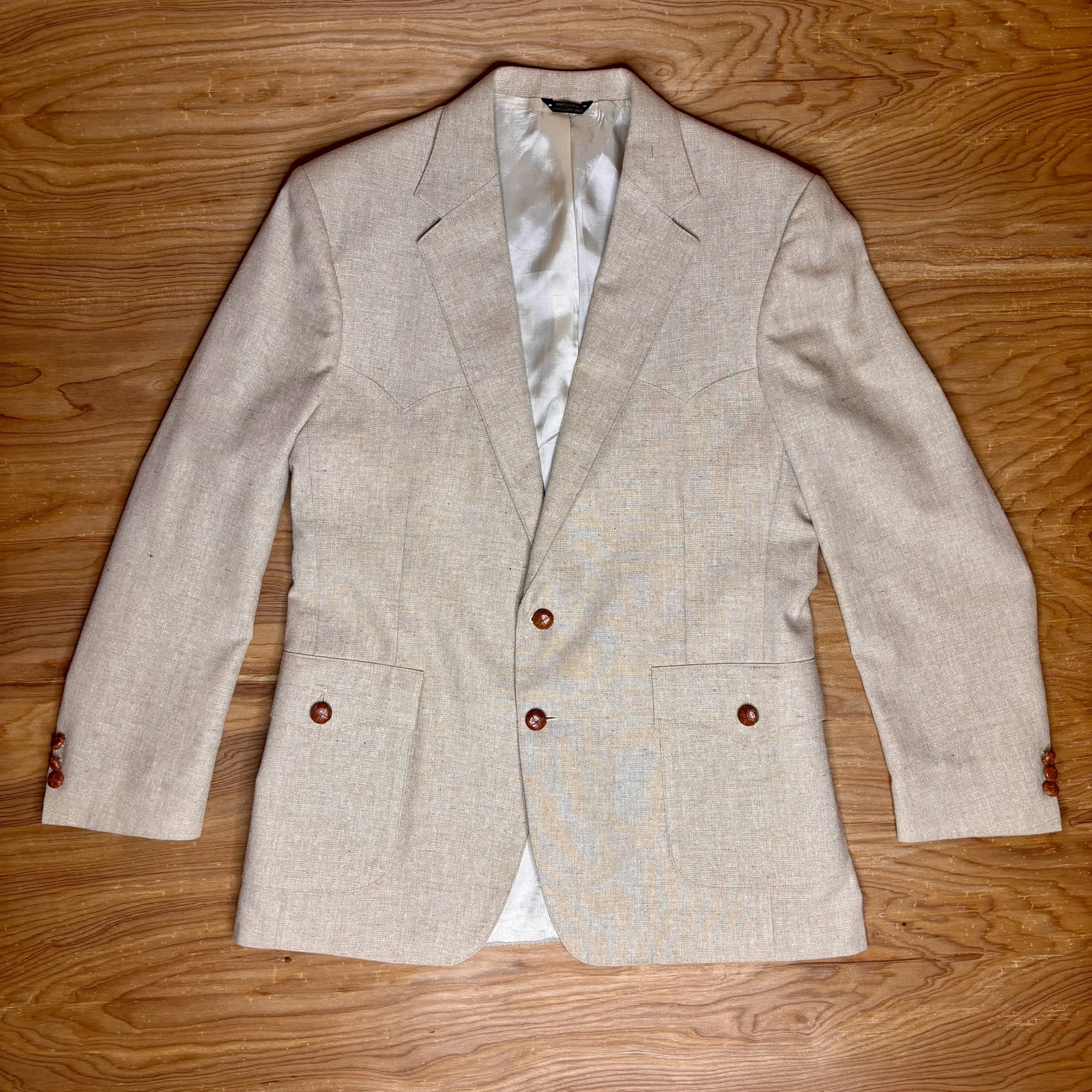 Front view of vintage Levi's Western Wear blazer in beige linen-blend, showing tailored fit, curved Western yokes, and caramel-colored buttons.