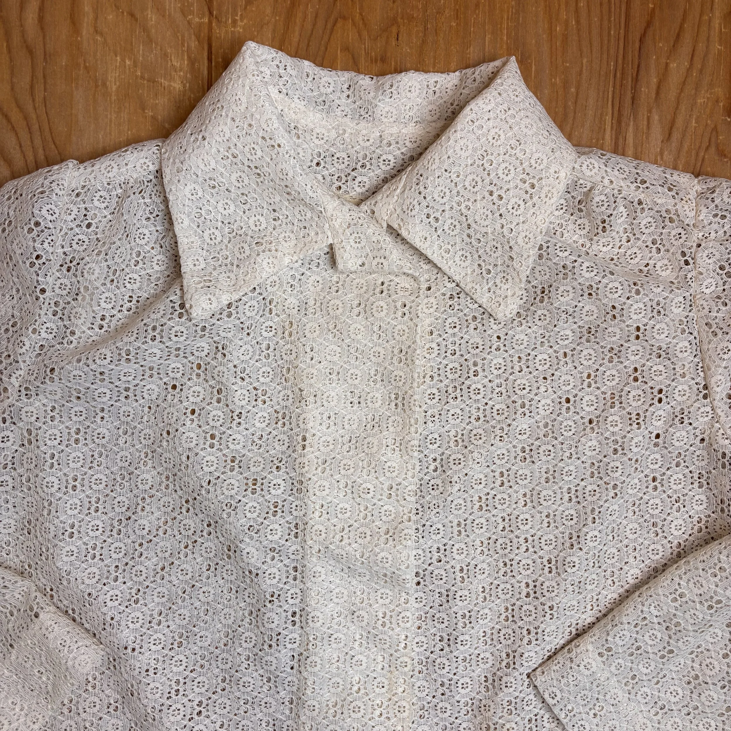 Detail of the oversized pointed collar and covered button placket.