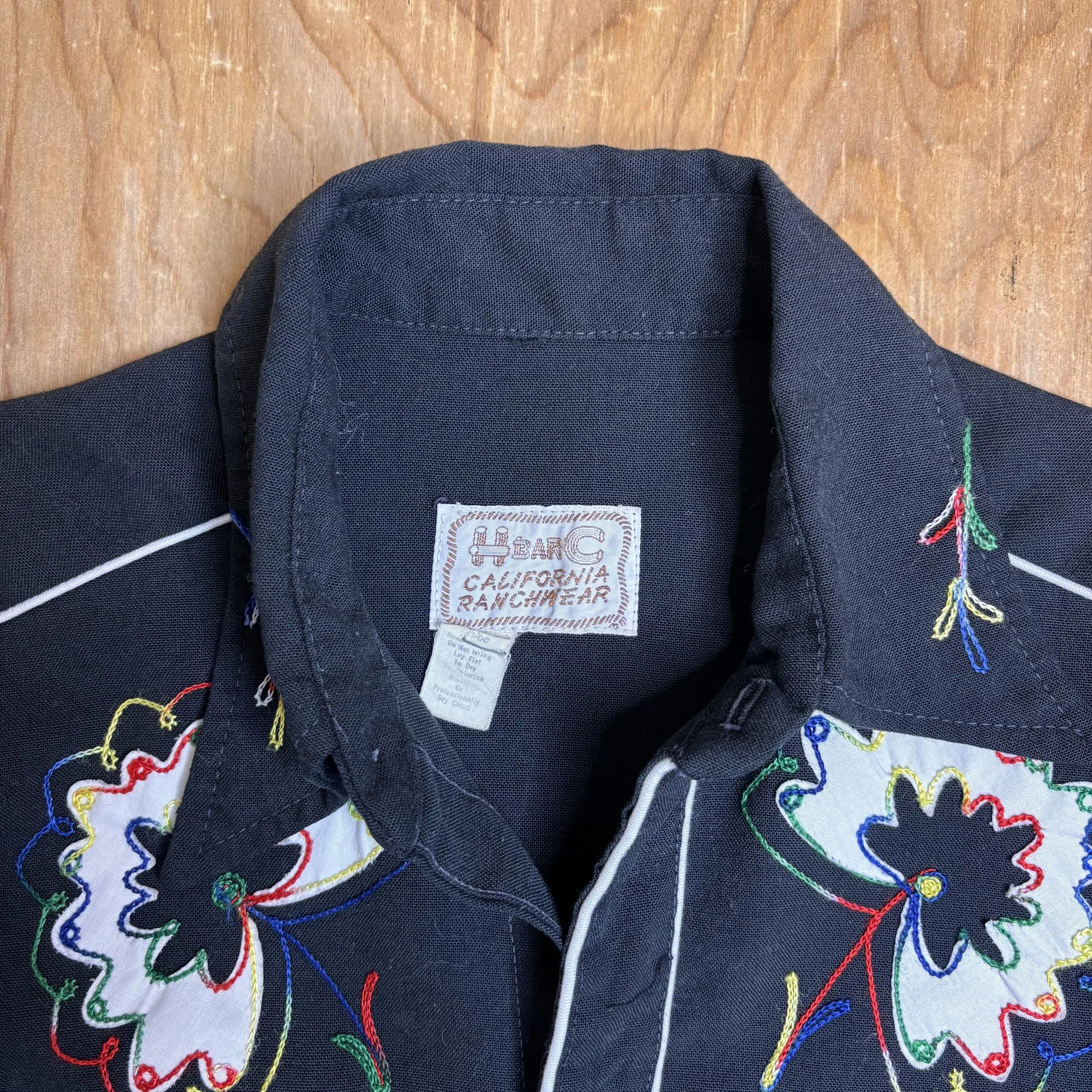 Tag view of H Bar C California Ranchwear label inside vintage embroidered pearl snap shirt.