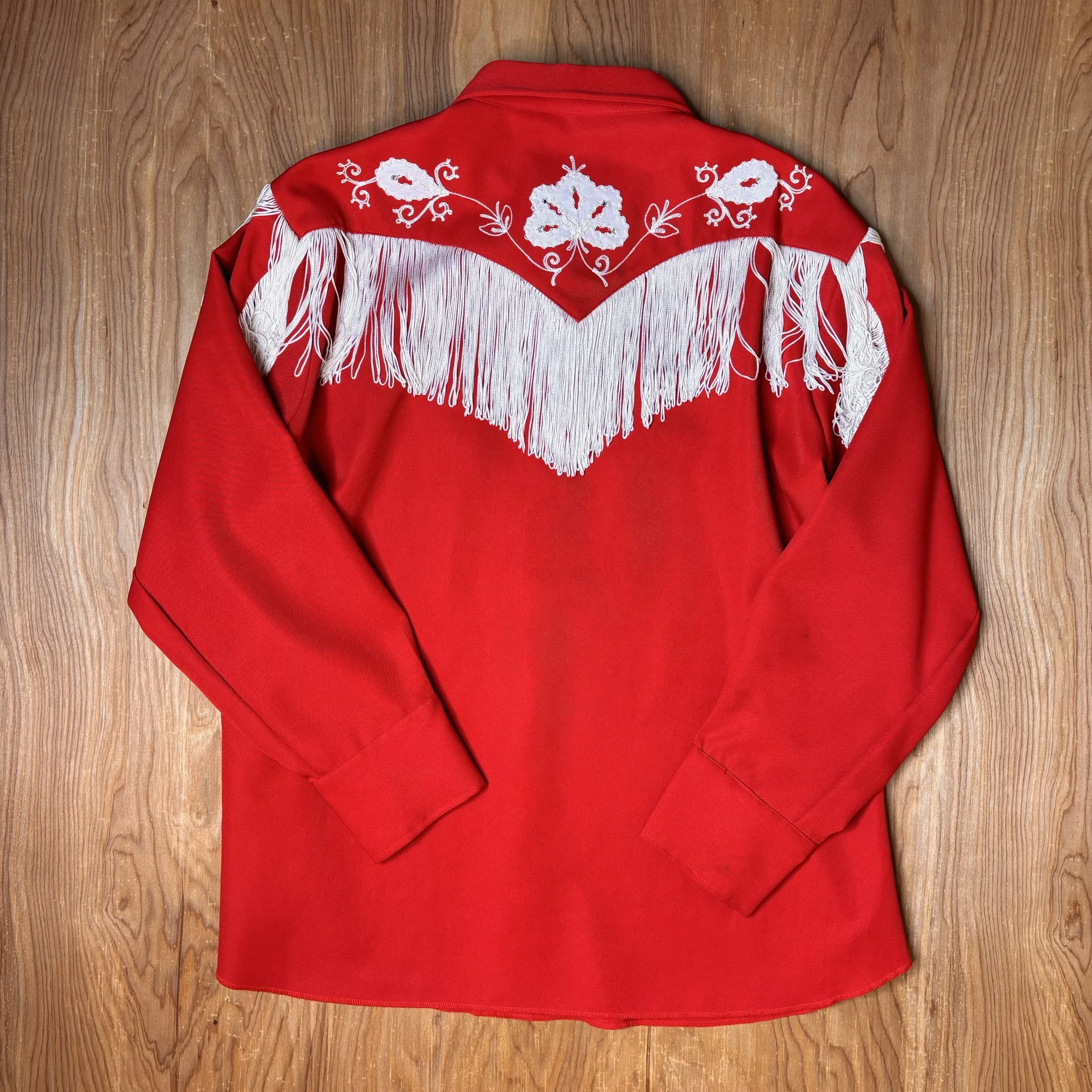Overhead view of the shirt’s back design, highlighting white fringe and embroidery patterns