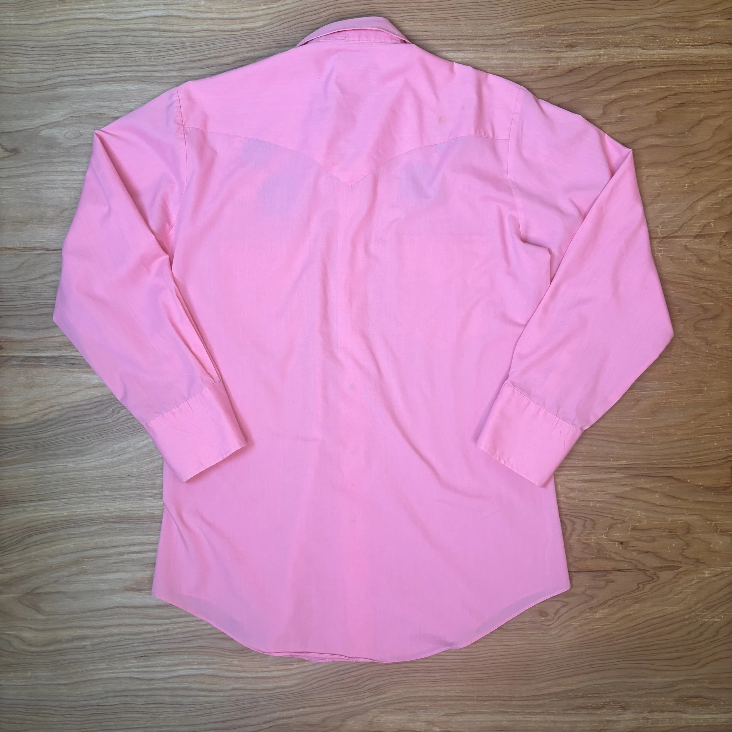 Back of vintage hot pink Karman western shirt with classic yoke detail, laid flat.