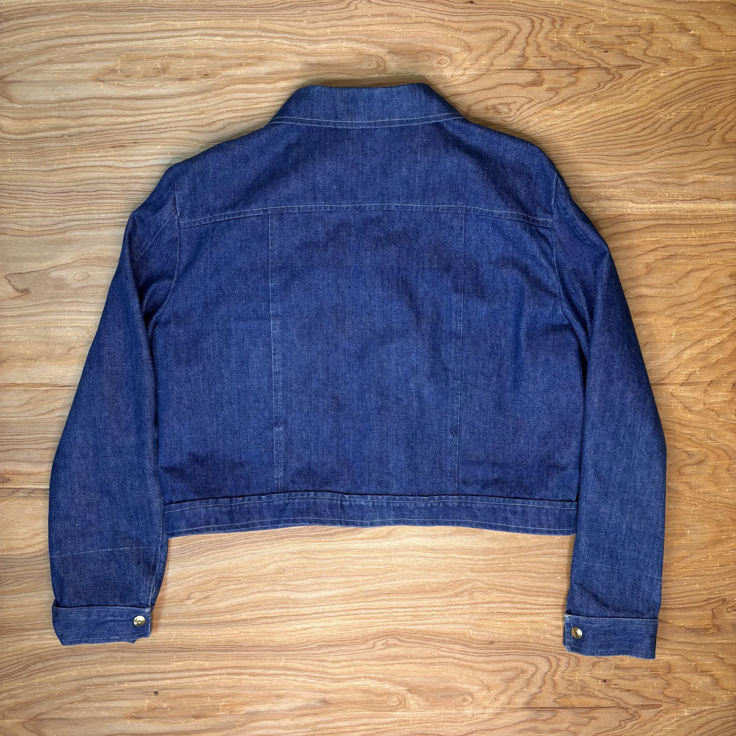 Back view of cropped denim jacket showing clean tailoring and no tags