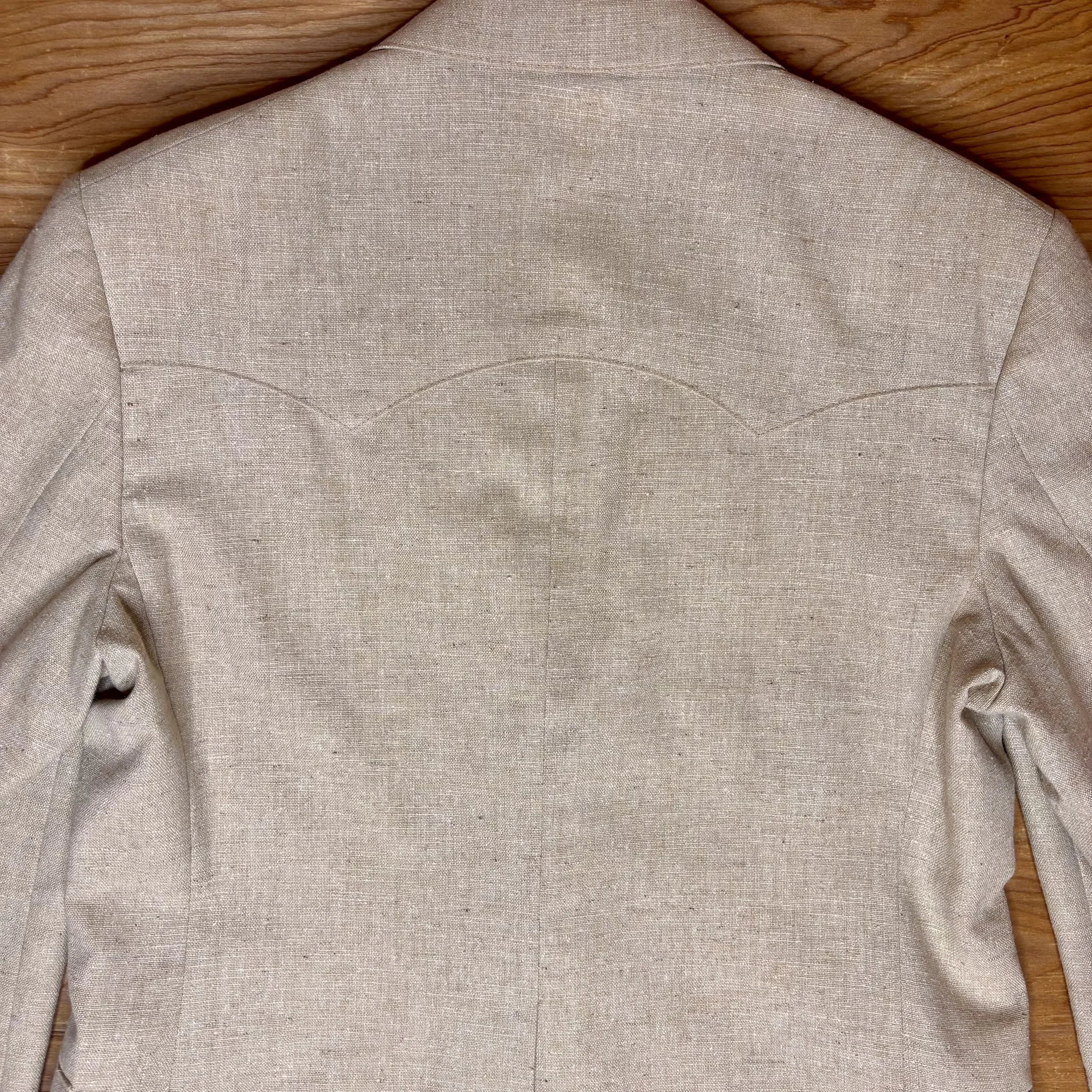 Close-up Back view highlighting subtle Western-style curved yoke detail on beige linen-blend Levi's blazer.