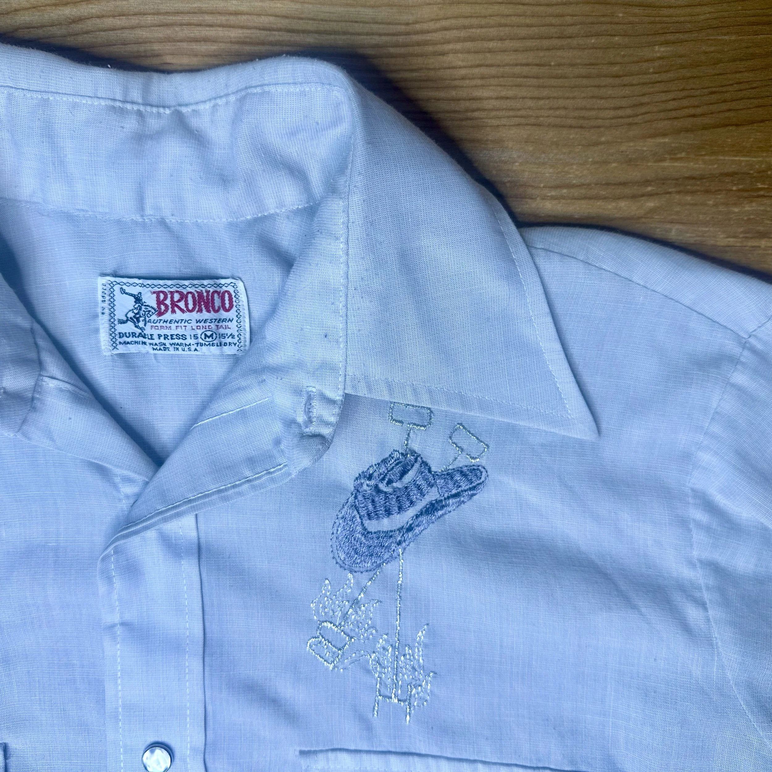 Close-up of Bronco Authentic Western tag and classic western collar on vintage pearl snap shirt.