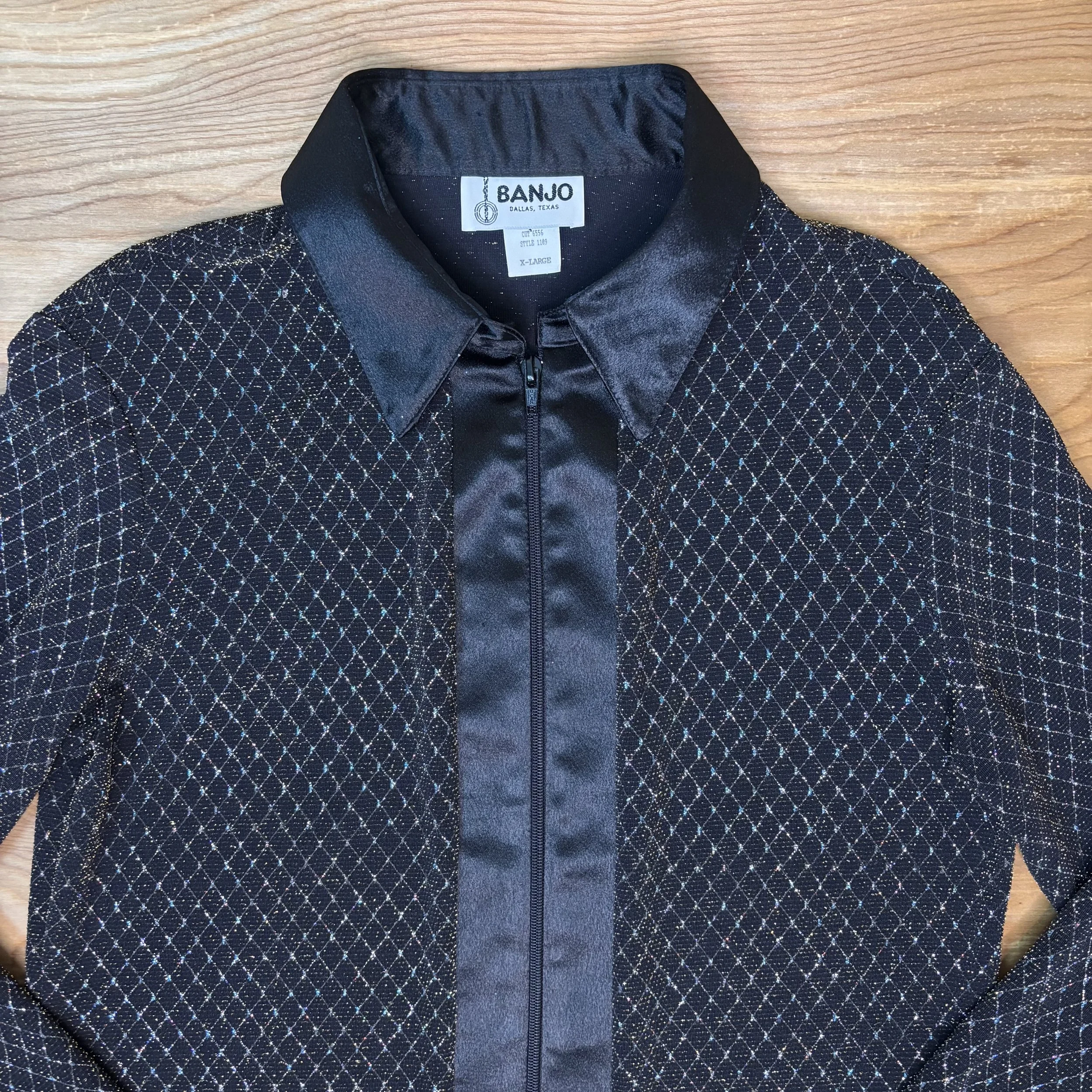 Close-up of sparkle detailing on black satin fabric of Banjo of Dallas shirt.