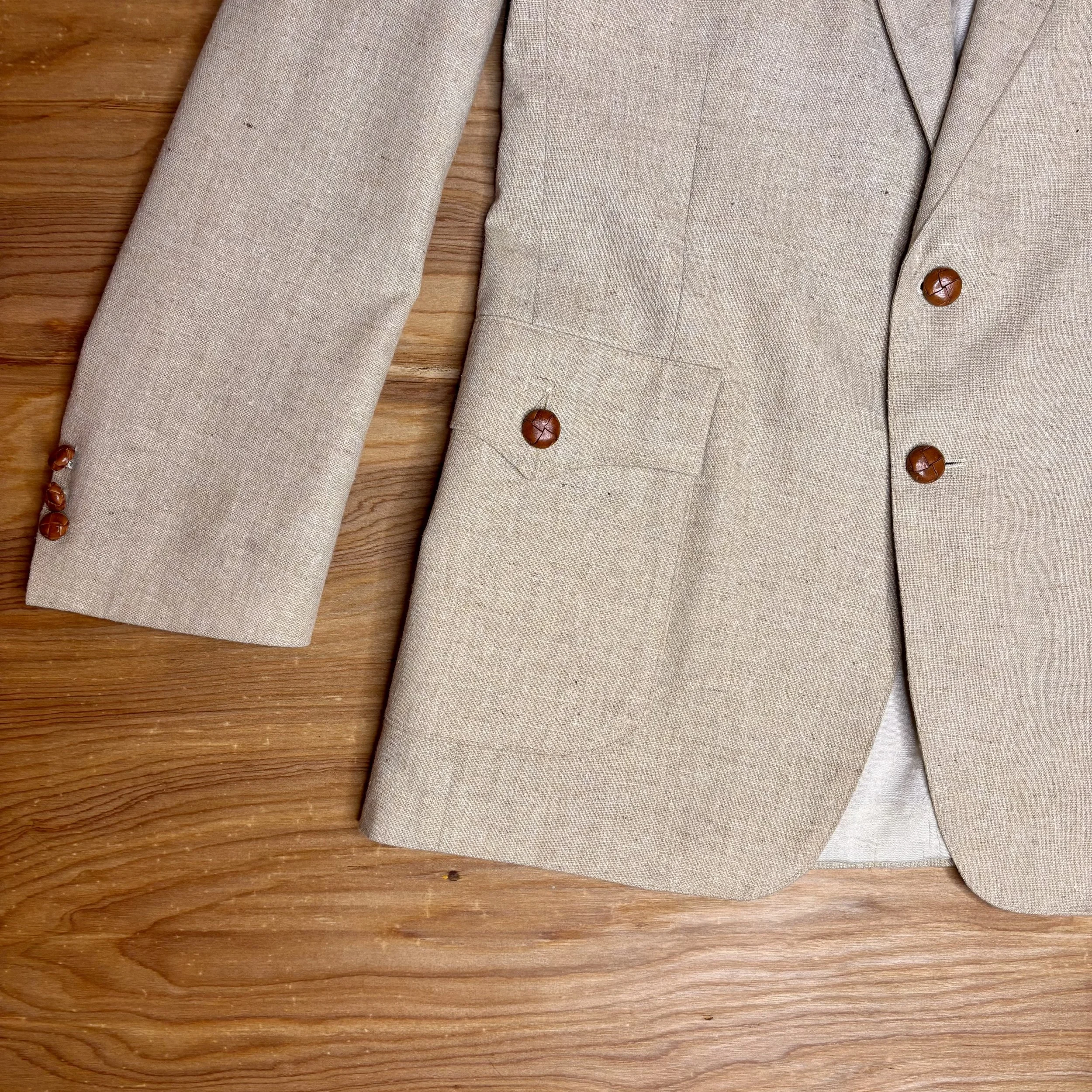 Close-up of structured pockets and sleeve detail with caramel-colored buttons on vintage Levi's blazer.
