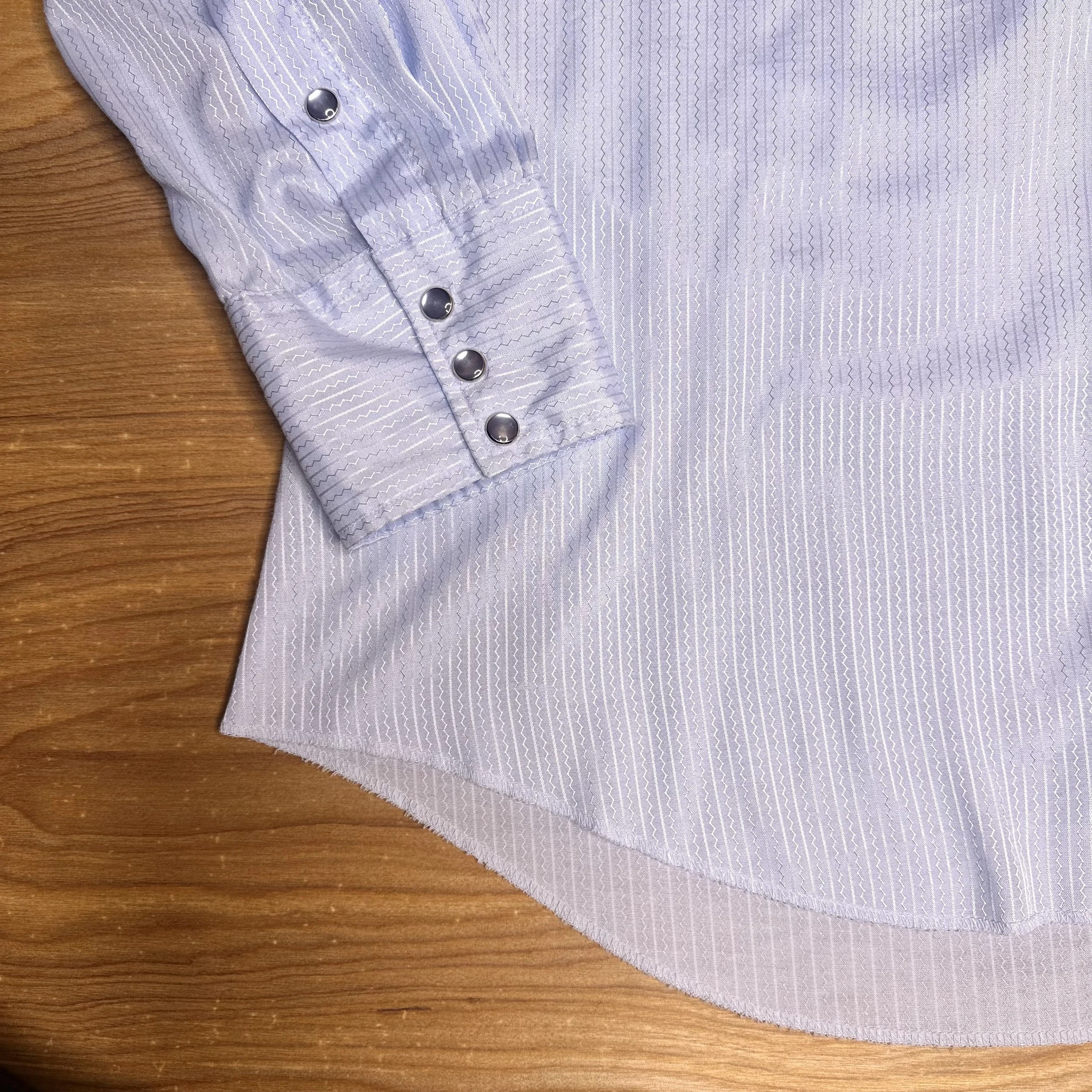 Close-up of pearlescent snaps on vintage Western shirt with satin finish.