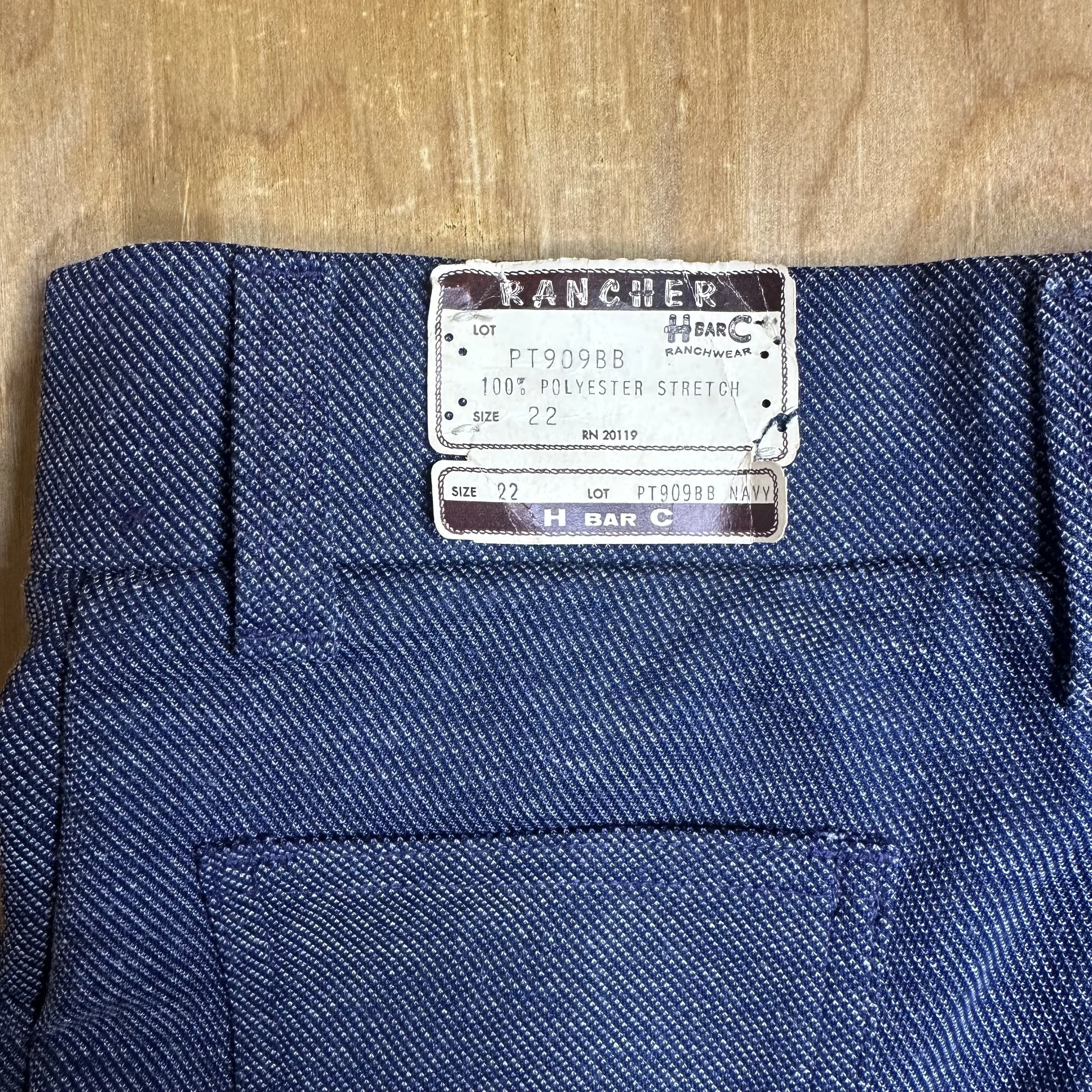 Close-up of H Bar C Ranchwear label on waistband, indicating deadstock condition with original tags attached.