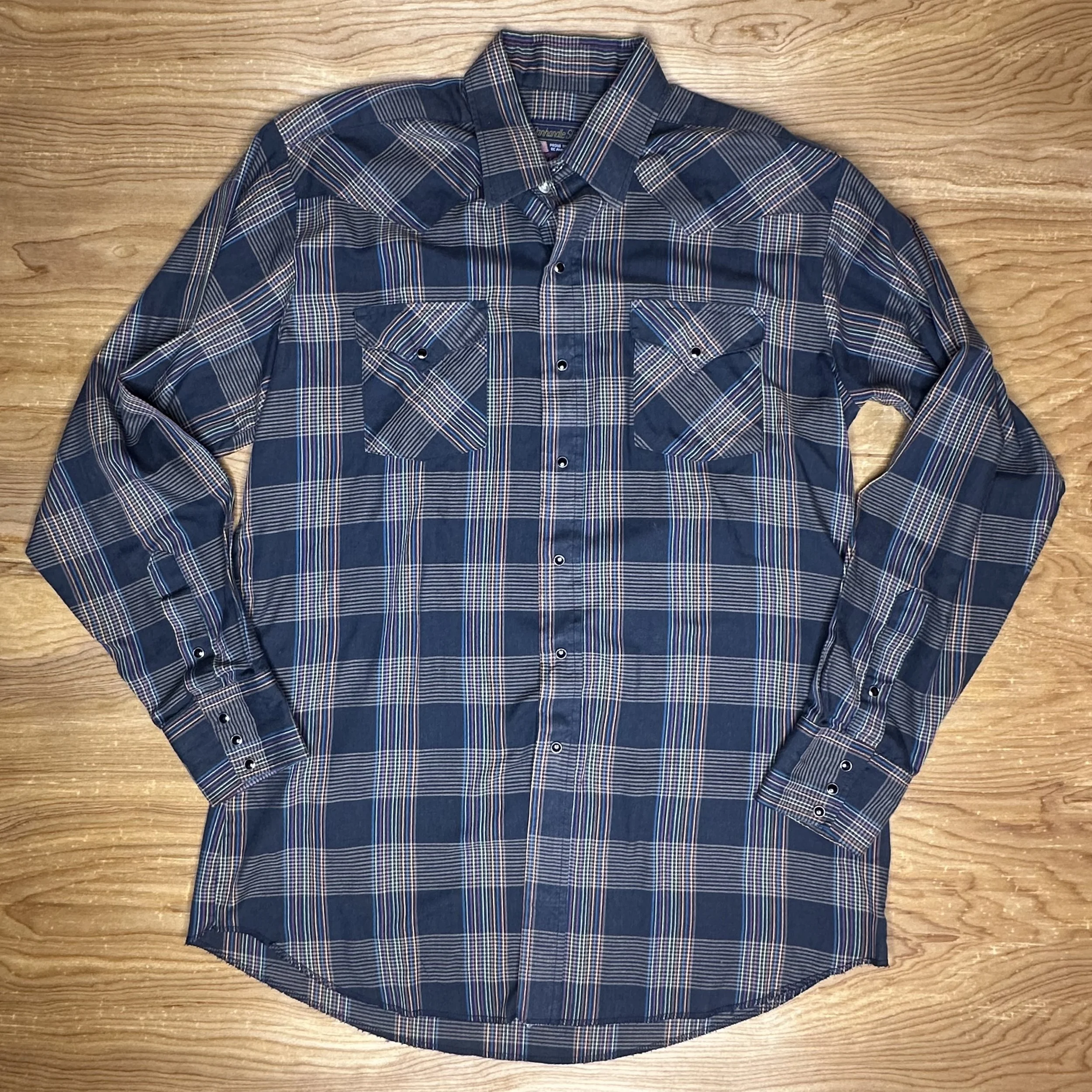 Front view of vintage Western-style shirt, highlighting rainbow plaid pattern, pearl snaps, and pointed yokes.