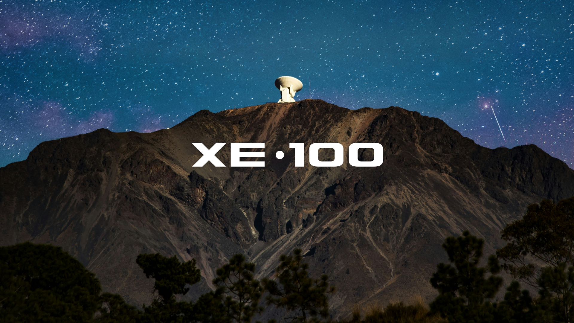Nighttime mountain landscape featuring a large radio telescope dish at the summit, with a starry sky and colorful aurora in the background, and the text 'XE•100' superimposed on the scene.