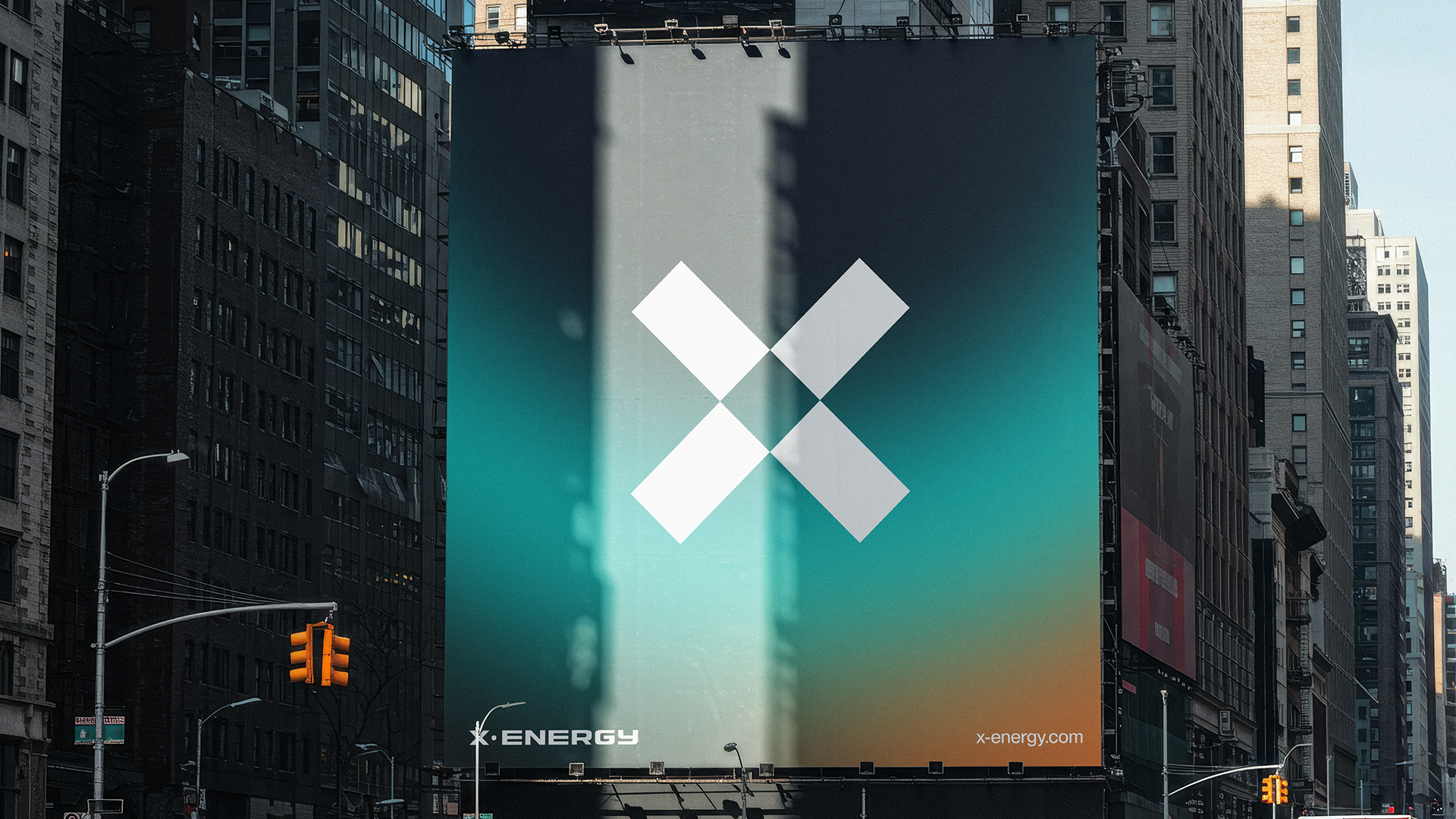 Large billboard advertisement for X-Energy on a city street, featuring a minimalist white X logo on a gradient background, with the website 'x-energy.com' and the company name 'X-ENERGY' at the bottom.