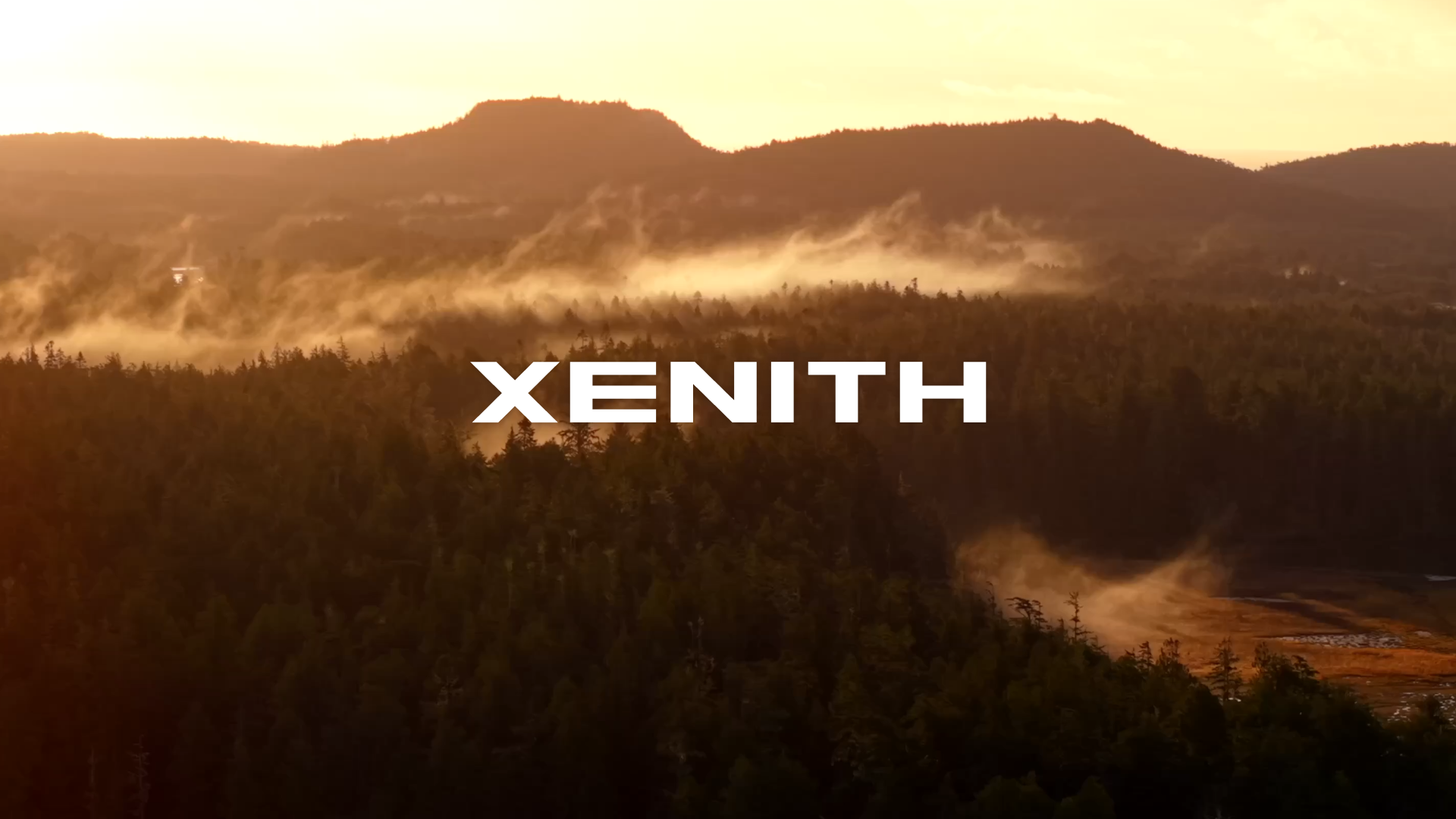 Sunset over mountains and forest with fog, with the word 'XENITH' in bold white letters at the center.