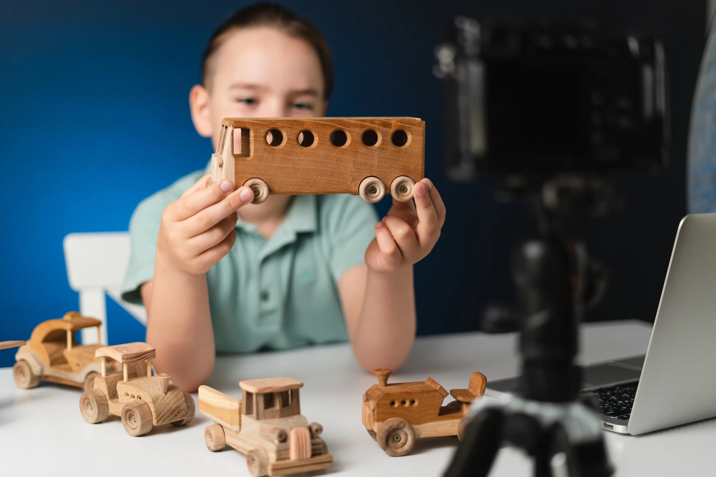 Child inspecting a wooden toy truck, representing the safety testing and conformity checks required for the toy category