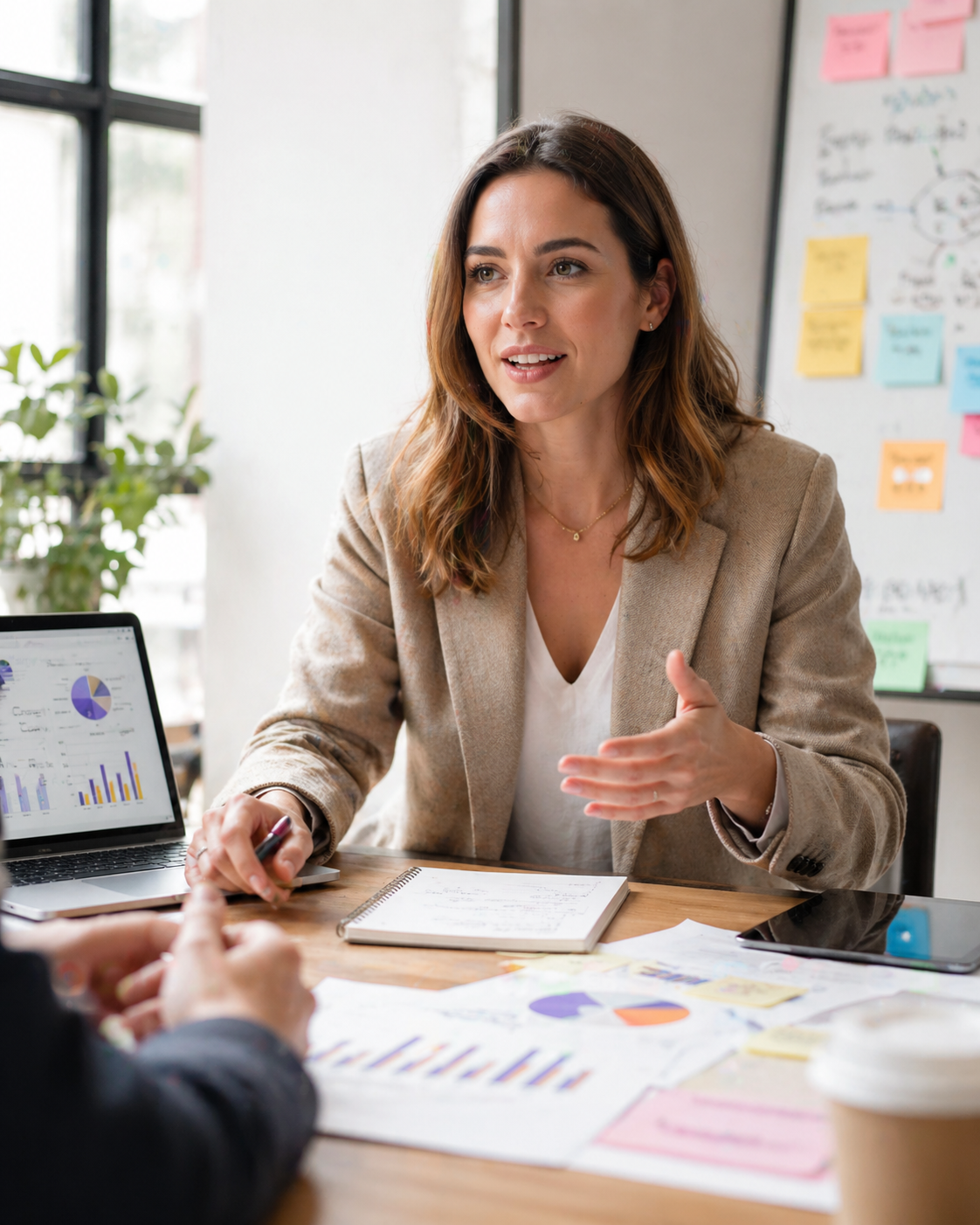 Consultant discussing e-commerce strategy in a planning meeting, with charts, notes, and a laptop showing performance data.