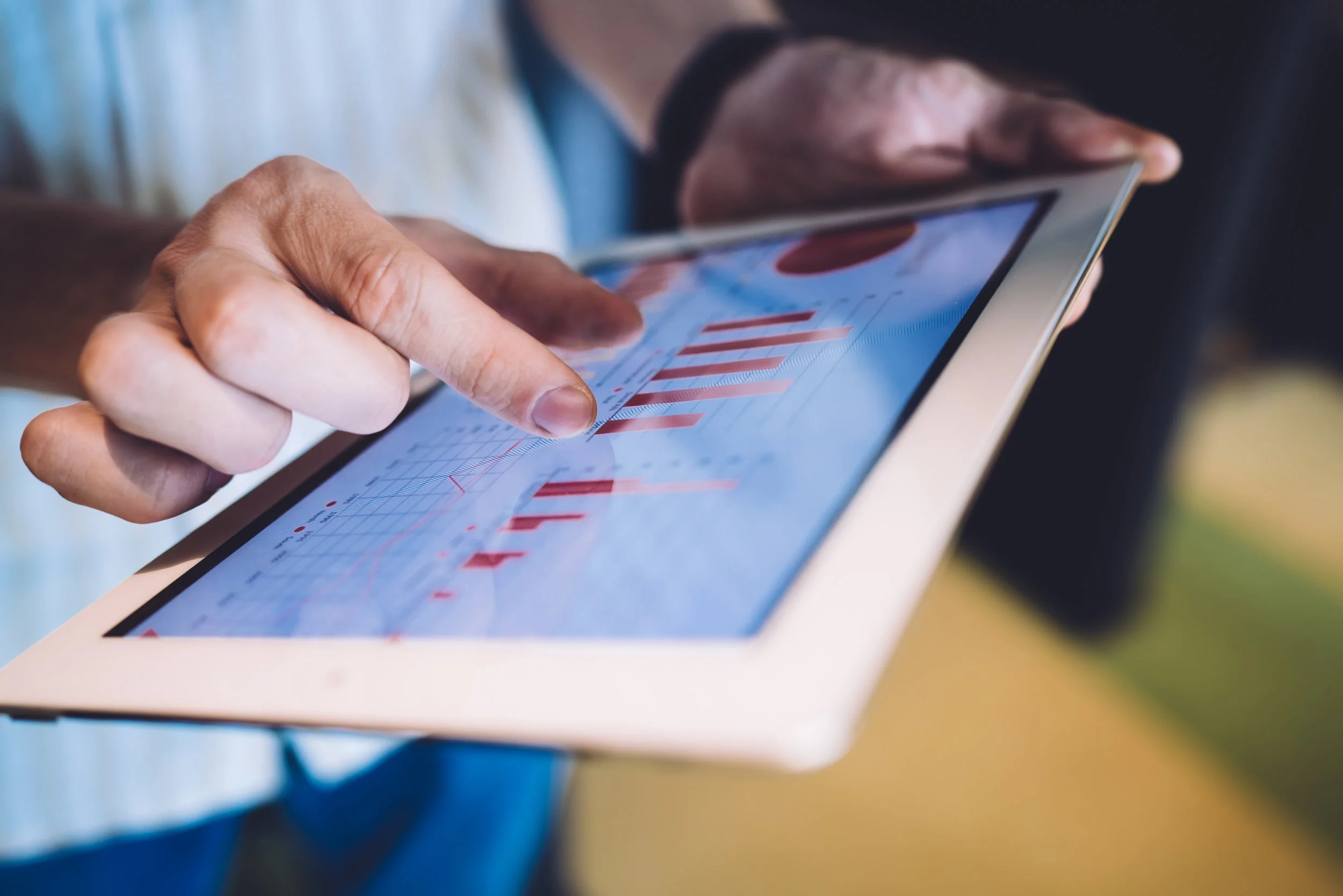 Person analyzing sales performance charts on a tablet, reviewing visible Amazon data trends