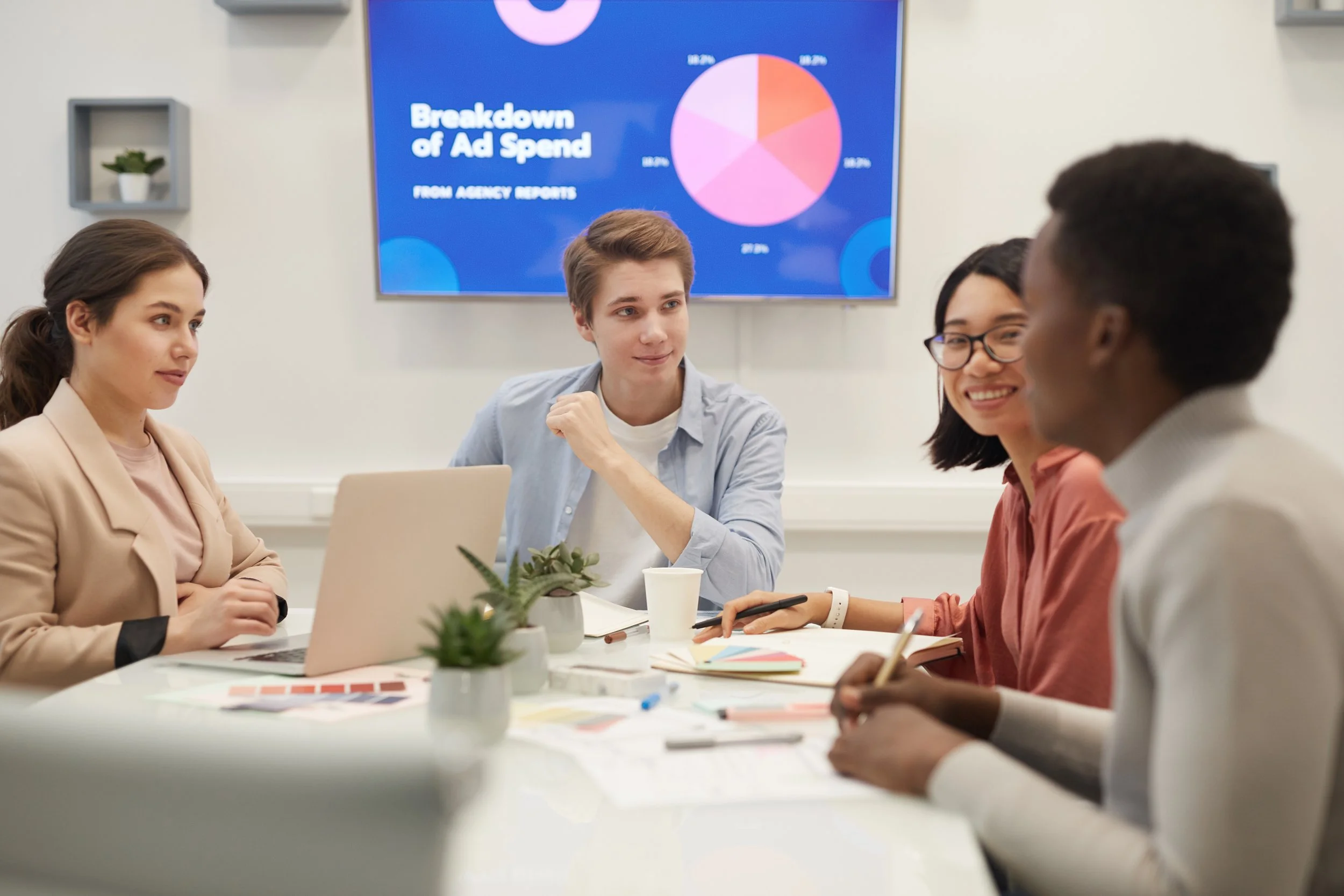 Team reviewing an ad spend breakdown chart during a meeting to diagnose marketing performance