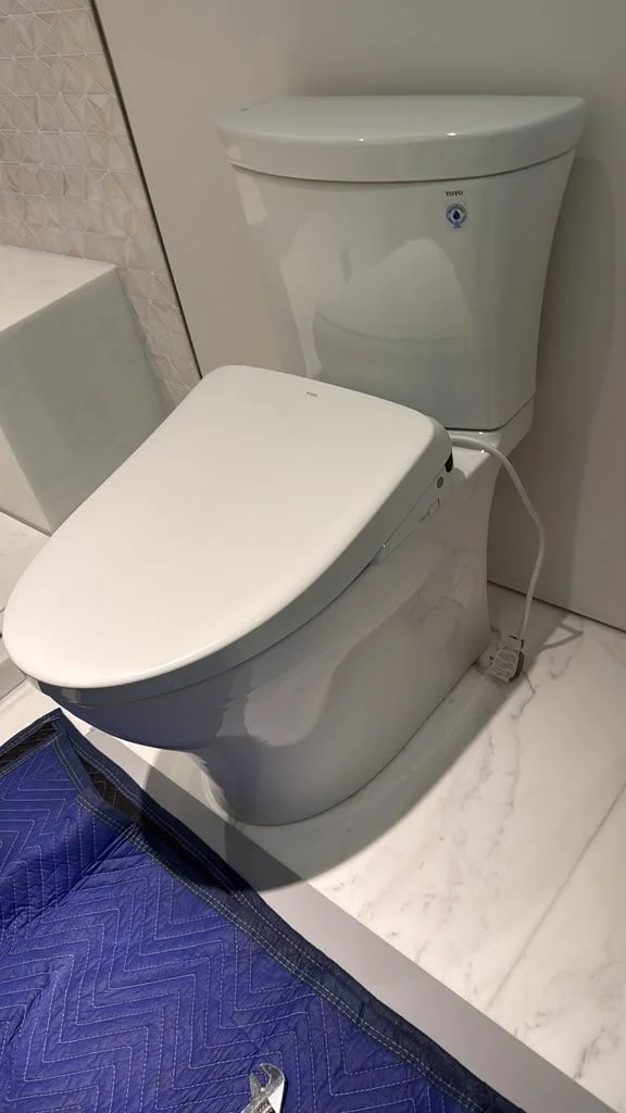 White toilet installed in a tiled residential bathroom