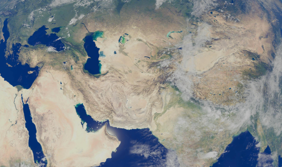 Satellite view of the Middle East and Asia, showing countries like Iran, Saudi Arabia, India, and surrounding regions with desert, mountains, and some cloud cover.