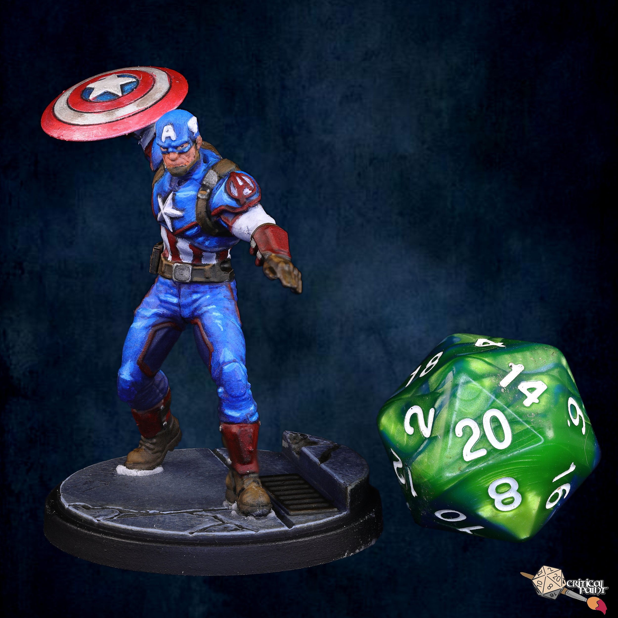 A figurine of Captain America in a heroic stance, holding his shield above his head, with a green and white 20-sided die and a black base with rocky terrain details nearby.