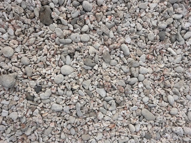 Close-up view of small, round, grayish-white pebbles and gravel.