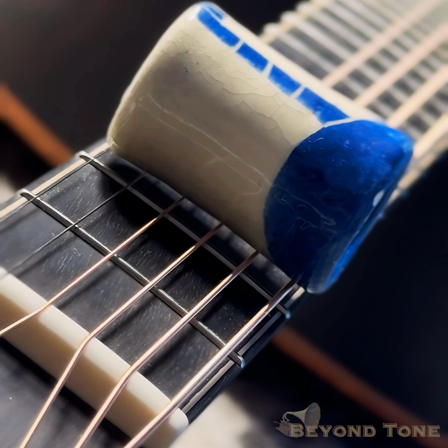 Close-up of a guitar bridge with a cream-colored pickup with a blue end cap.