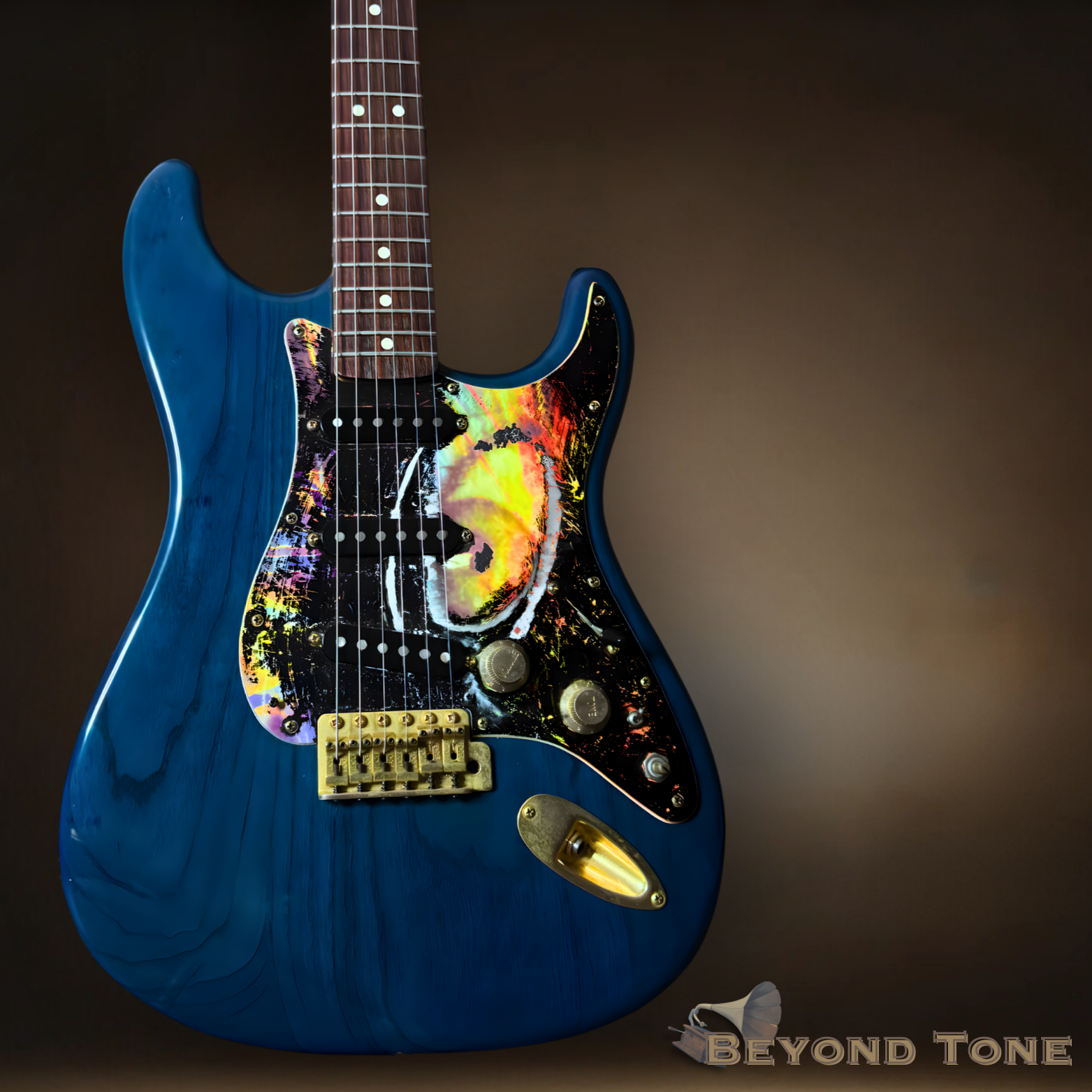 Electric guitar with a blue body, a painted pickguard featuring a colorful abstract design with yellow, orange, pink, and black, and gold hardware, set against a dark background.