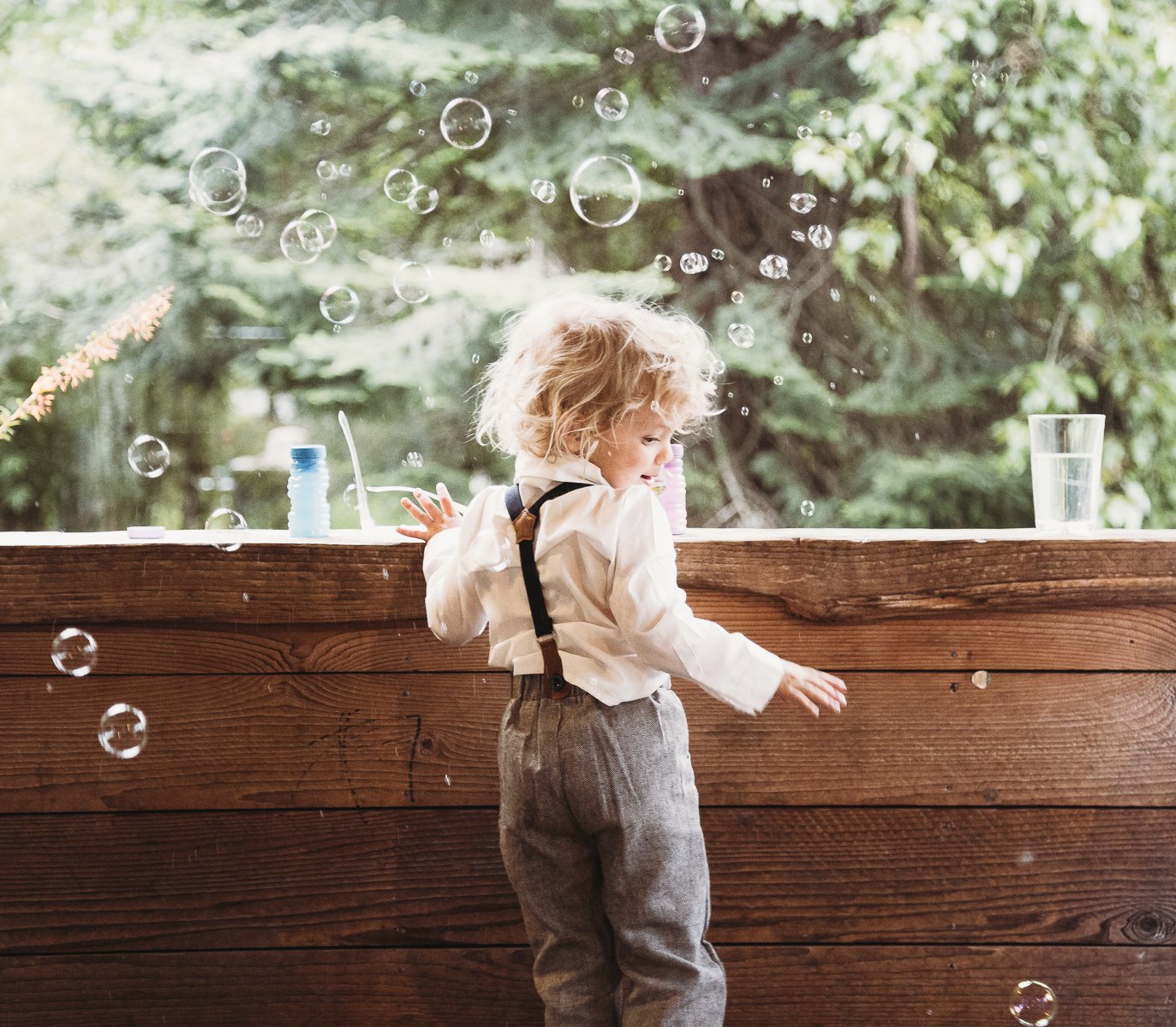 Child playing with bubbles on a wooden porch