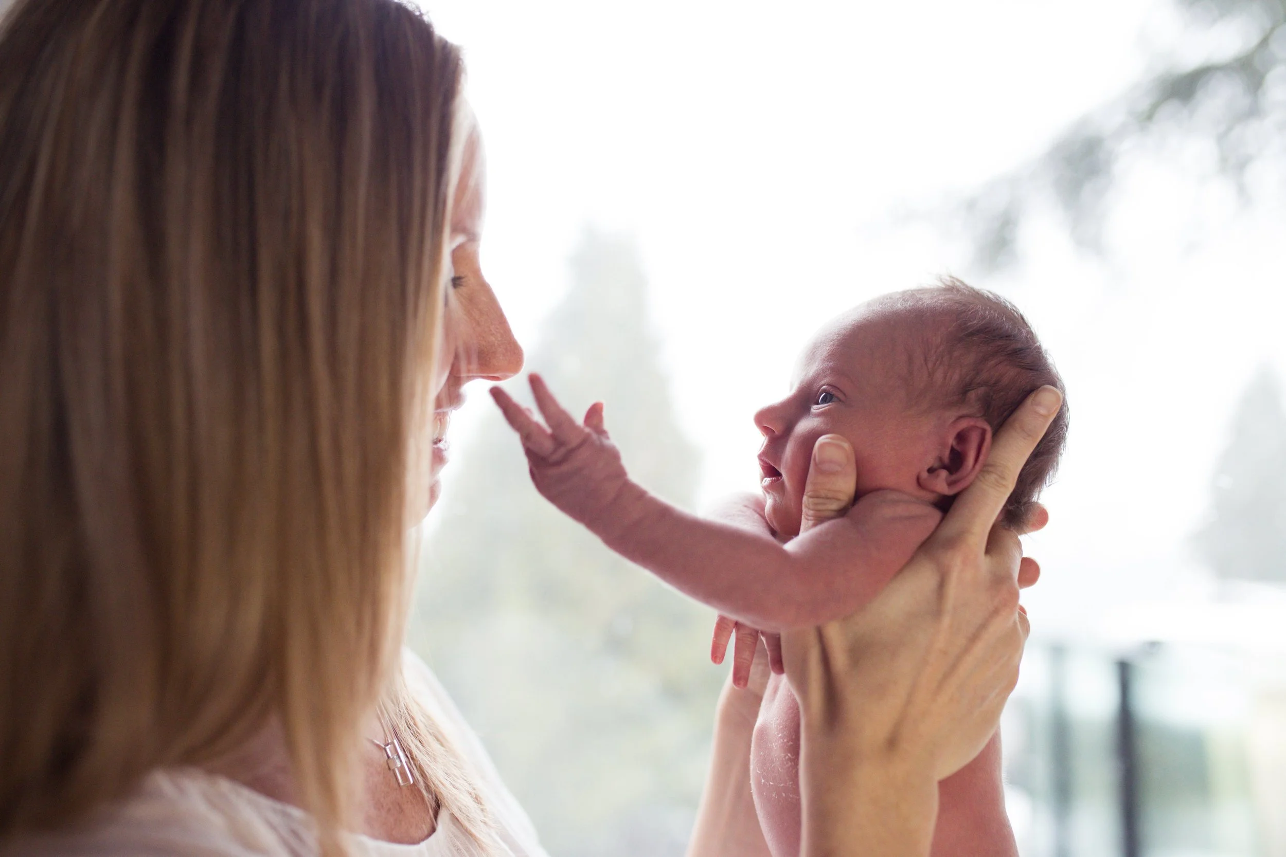 Woman holding newborn baby and smiling