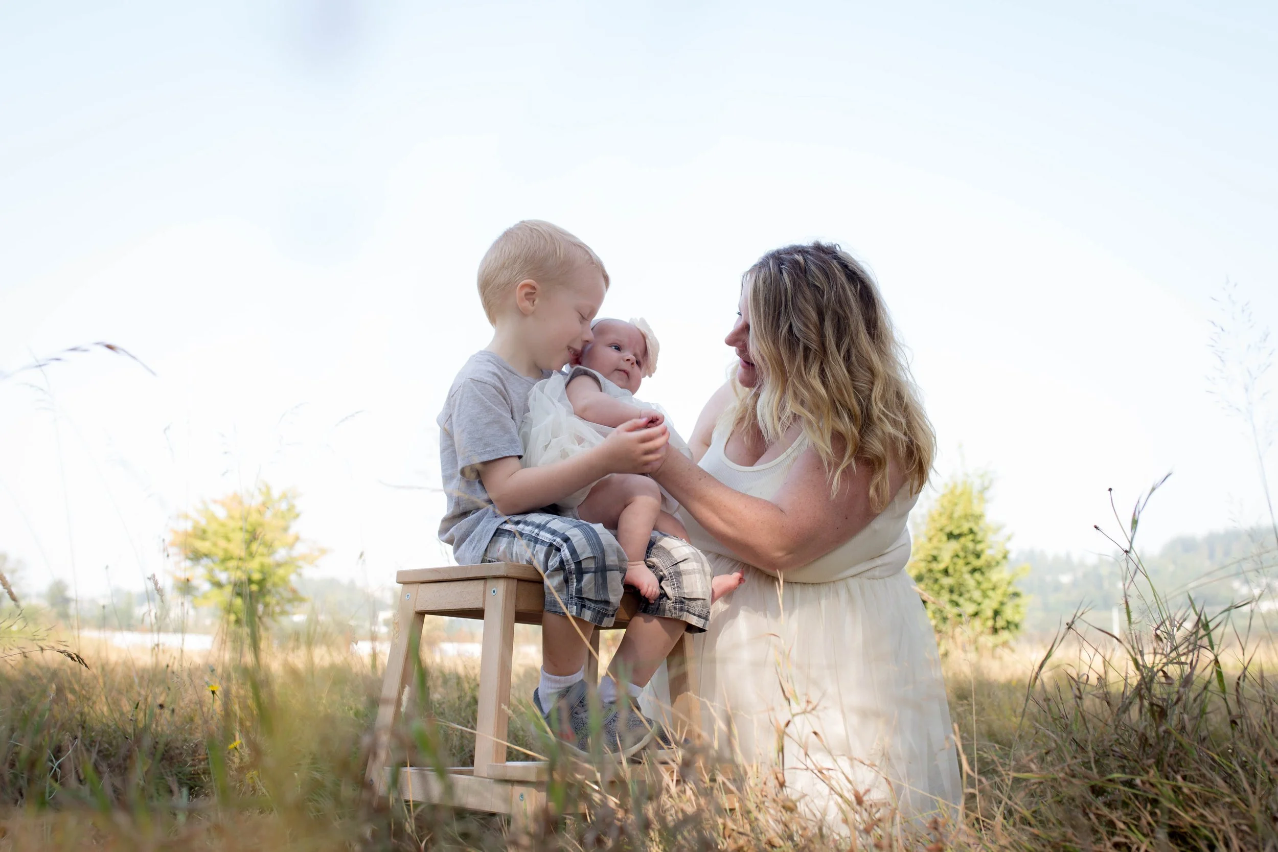 Family with children outdoors, woman and kids in grassy field, joyful moment.
