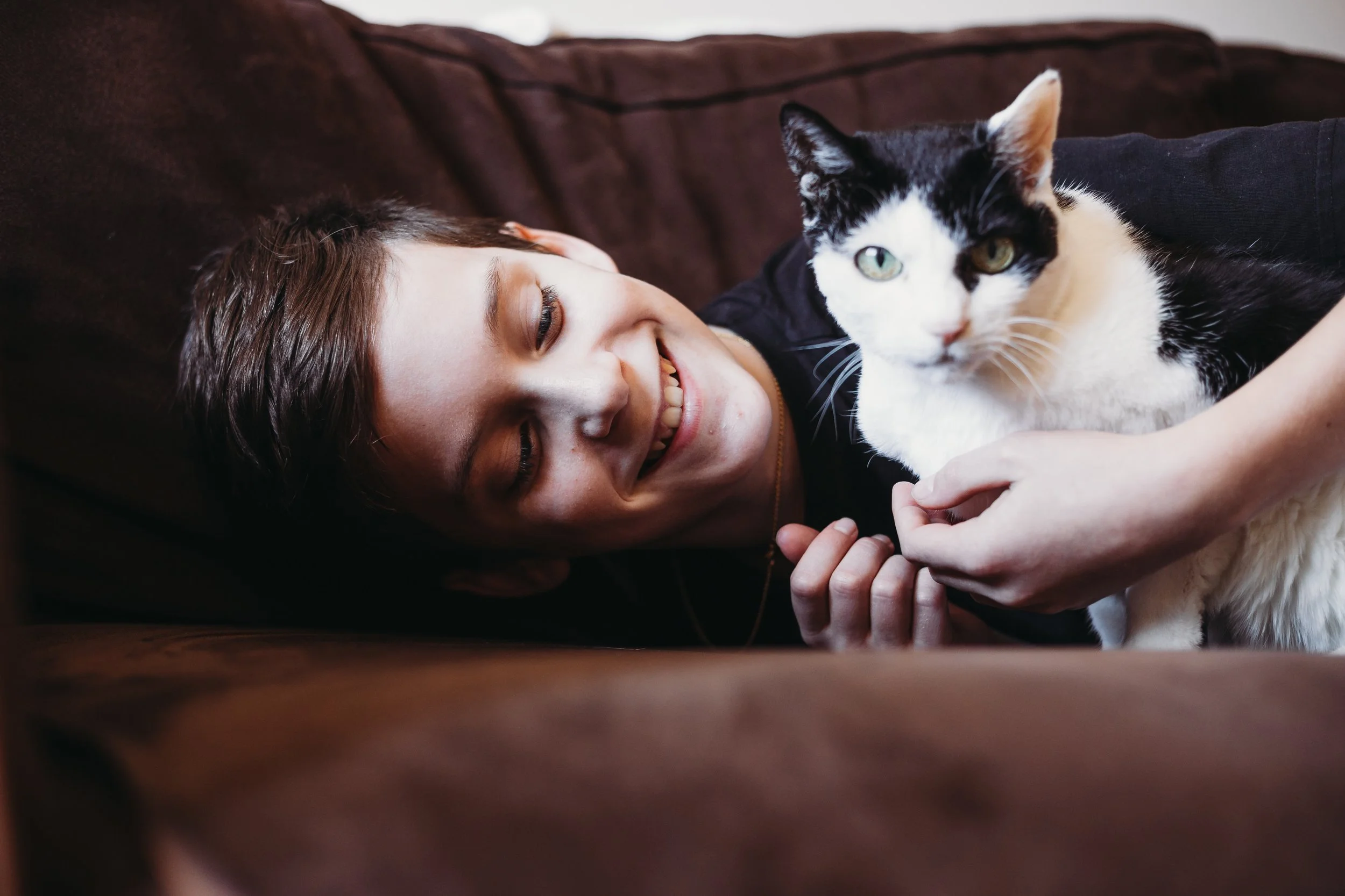 Smiling child with black and white cat indoors