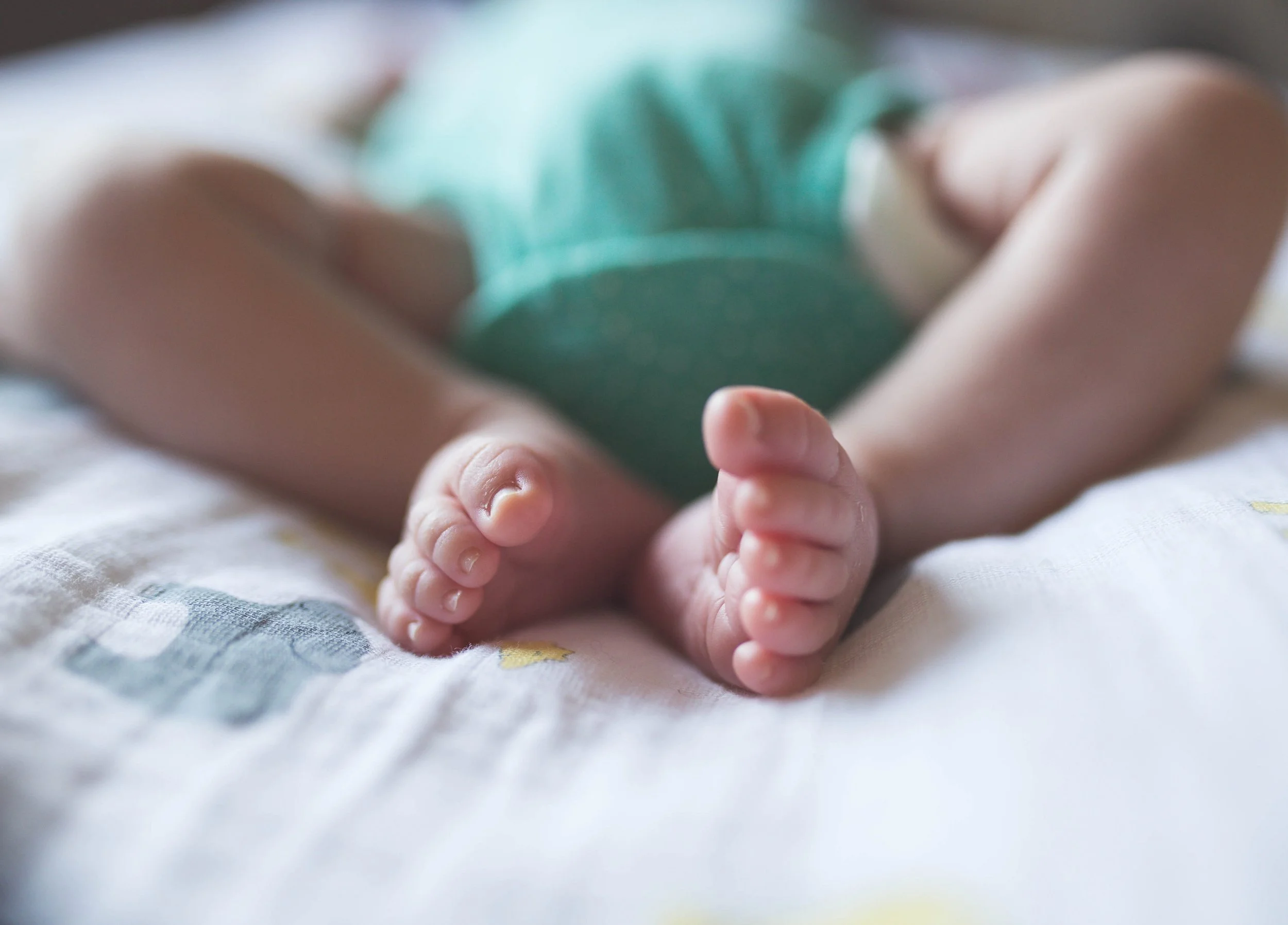 Close-up of a baby's feet on a soft blanket.