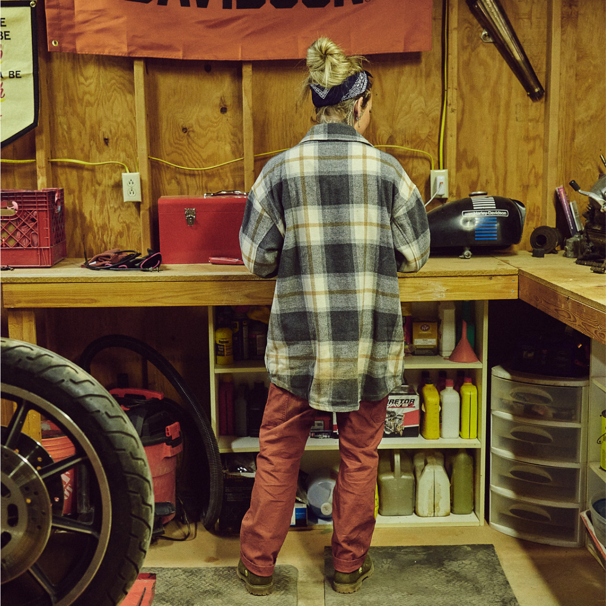 Photo of Woman wearing Flannel Shirt from behind in garage Jacket